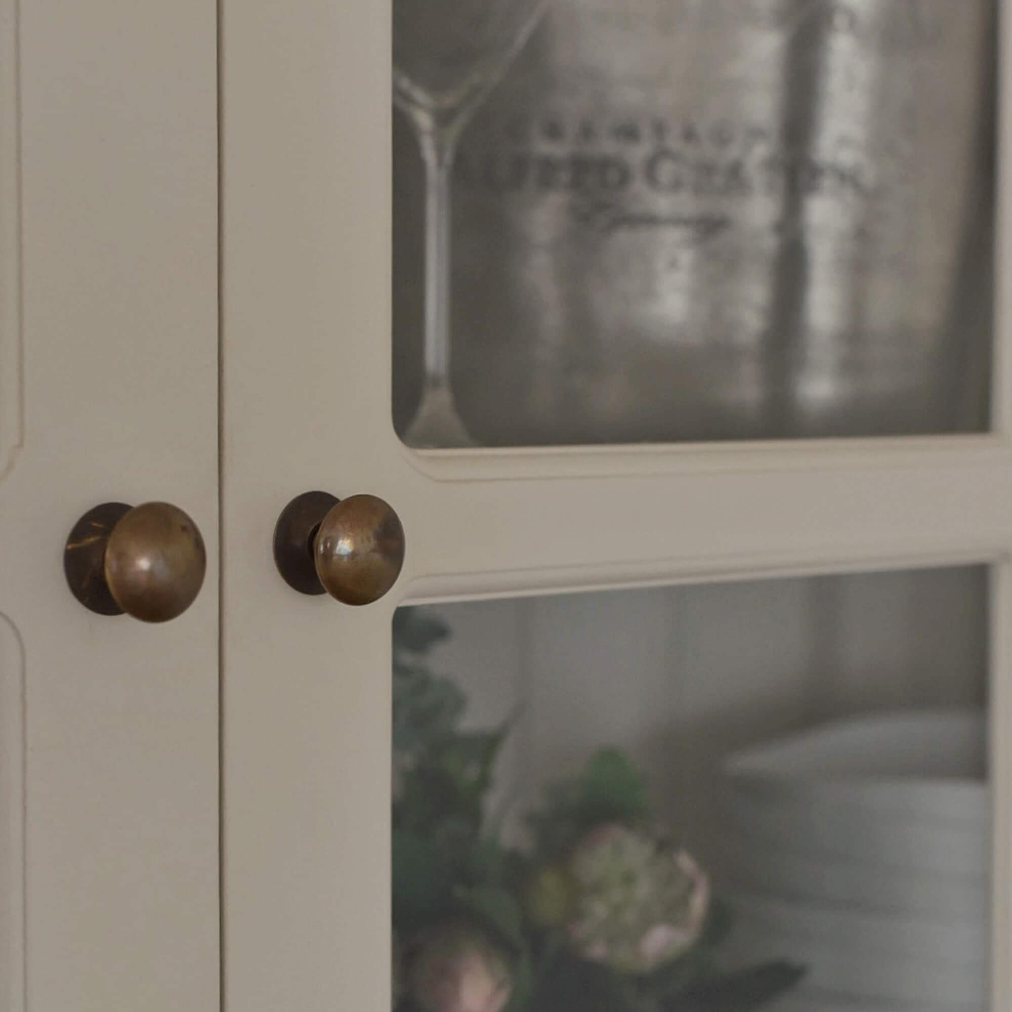 Detail van witte houten kast met messing knoppen, rustieke stijl, opbergmeubel