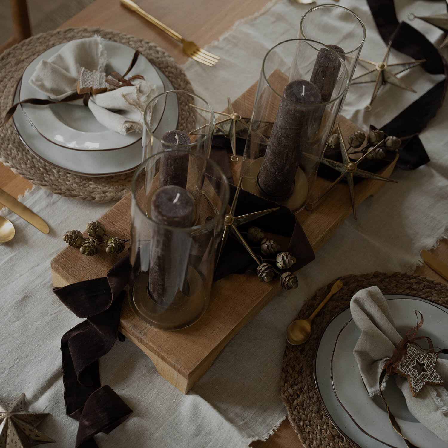 Kersttafel met bruine kaarsen in glas en natuurlijke decoraties voor een warme sfeer