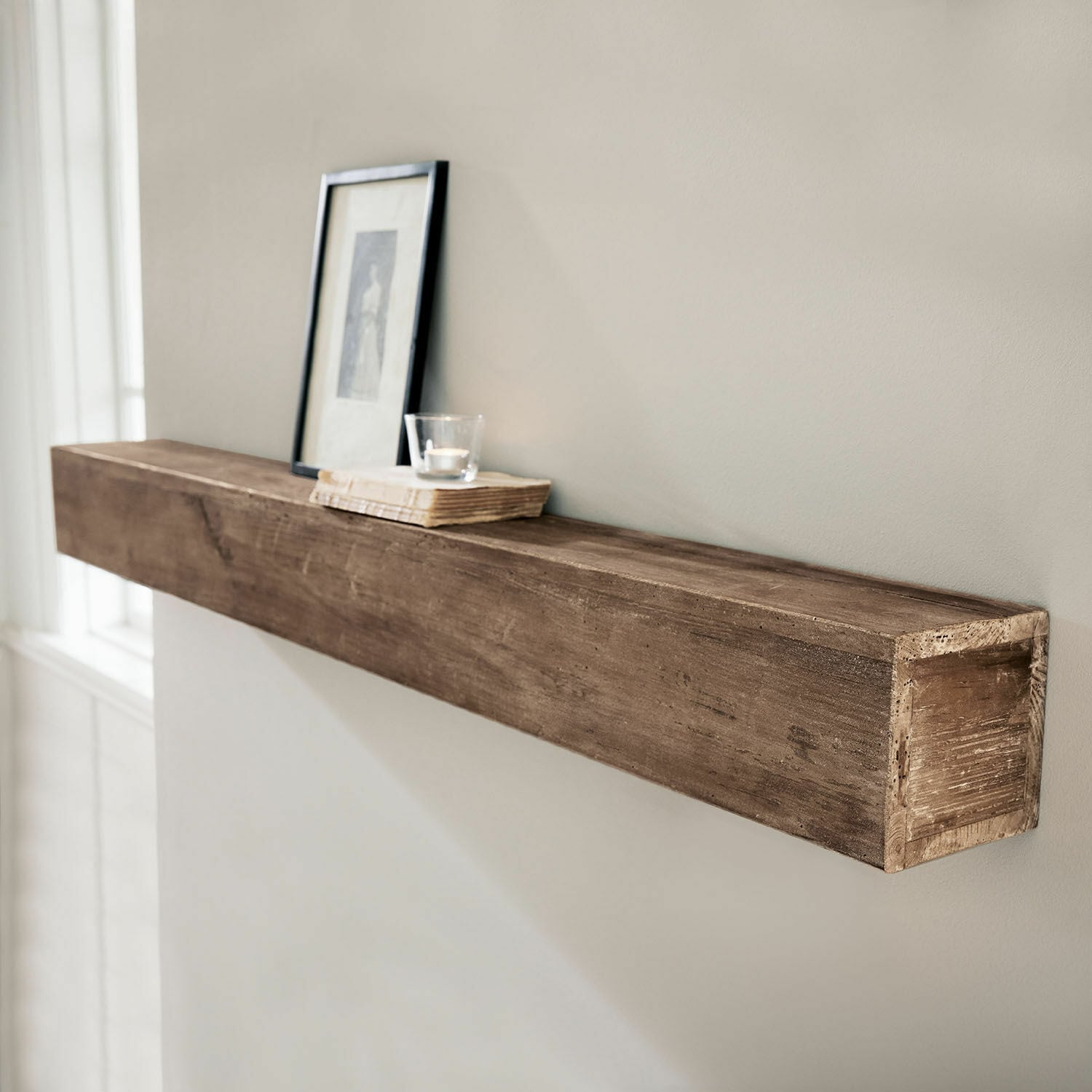 Wandplank Visayas Bruine houten wandplank met decoratieve lijst en kaars op een boek