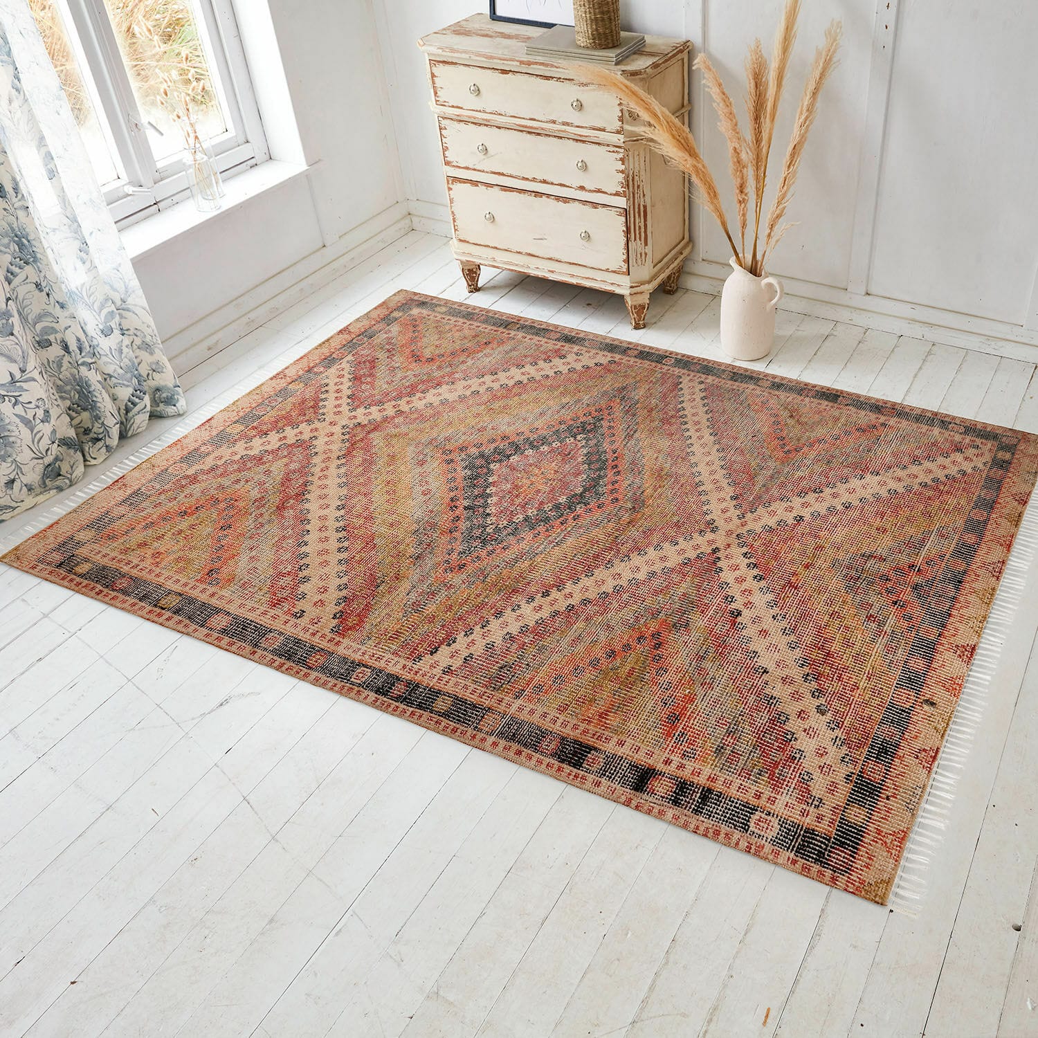 Vloerkleed voor binnen en buiten Mildura Vloerkleed met geometrisch patroon in warme rood- en beigetinten op lichte houten vloer