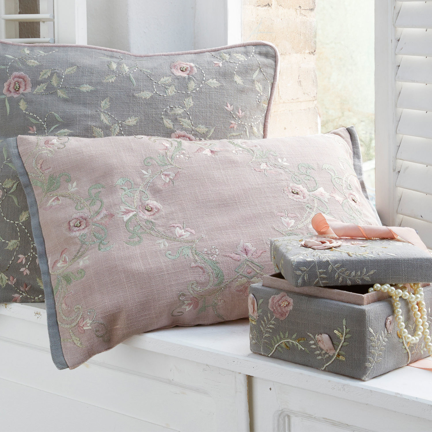 Roze en grijs linnen kussen met bloemenborduurwerk en grijze geborduurde sieradendoos