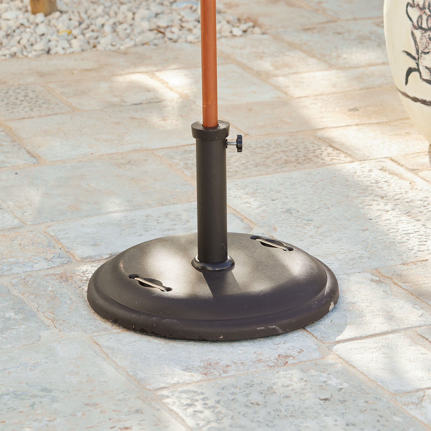 Parasolvoet Yarra Zwarte metalen parasolvoet op stenen vloer voor tuin of terras