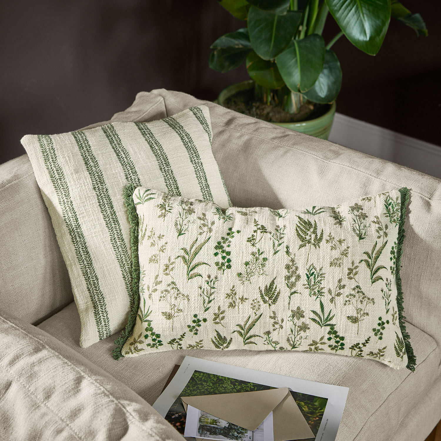 Draaibare katoenen sierkussens met groene plantenpatronen en strepen op beige bank