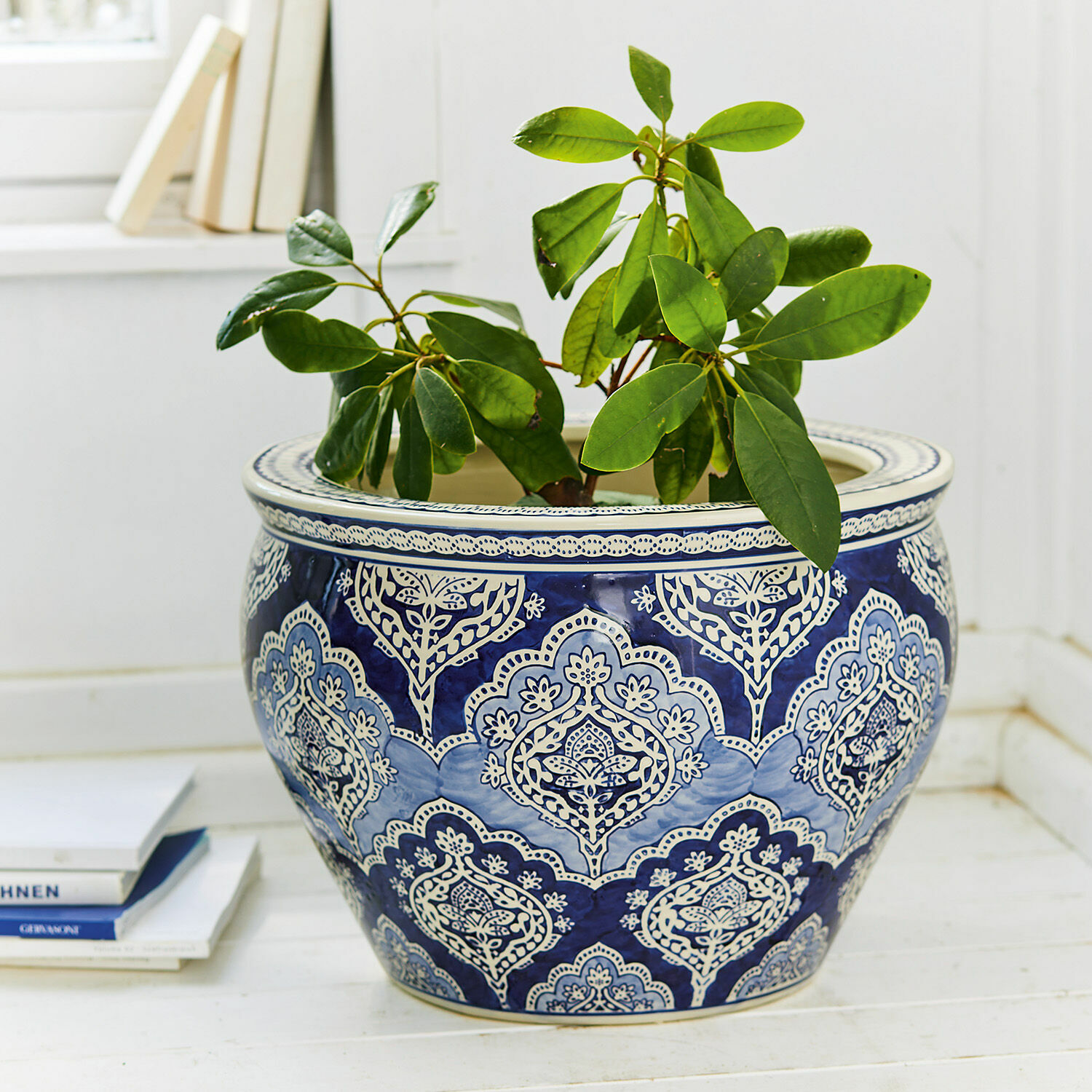 Sierpot Aurélie Blauw-witte keramische bloempot met groene plant op lichte vloer, stijlvolle interieurdecoratie