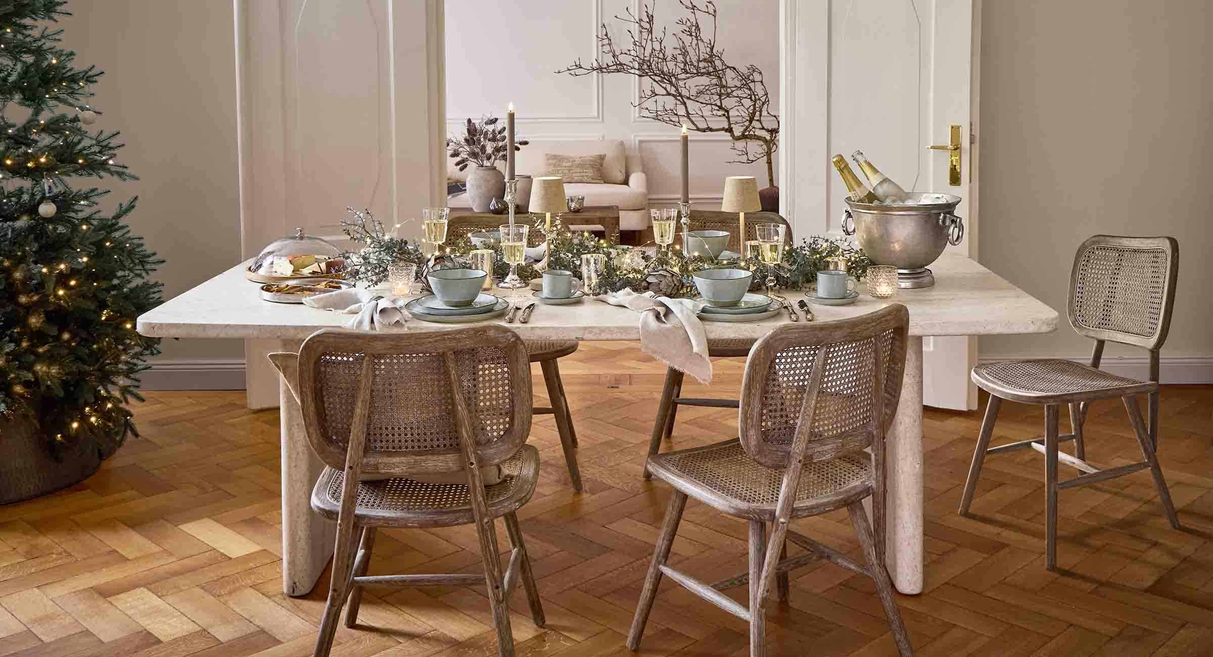 Elegante eettafel met licht marmeren blad en houten stoelen met rotan, feestelijke decoratie