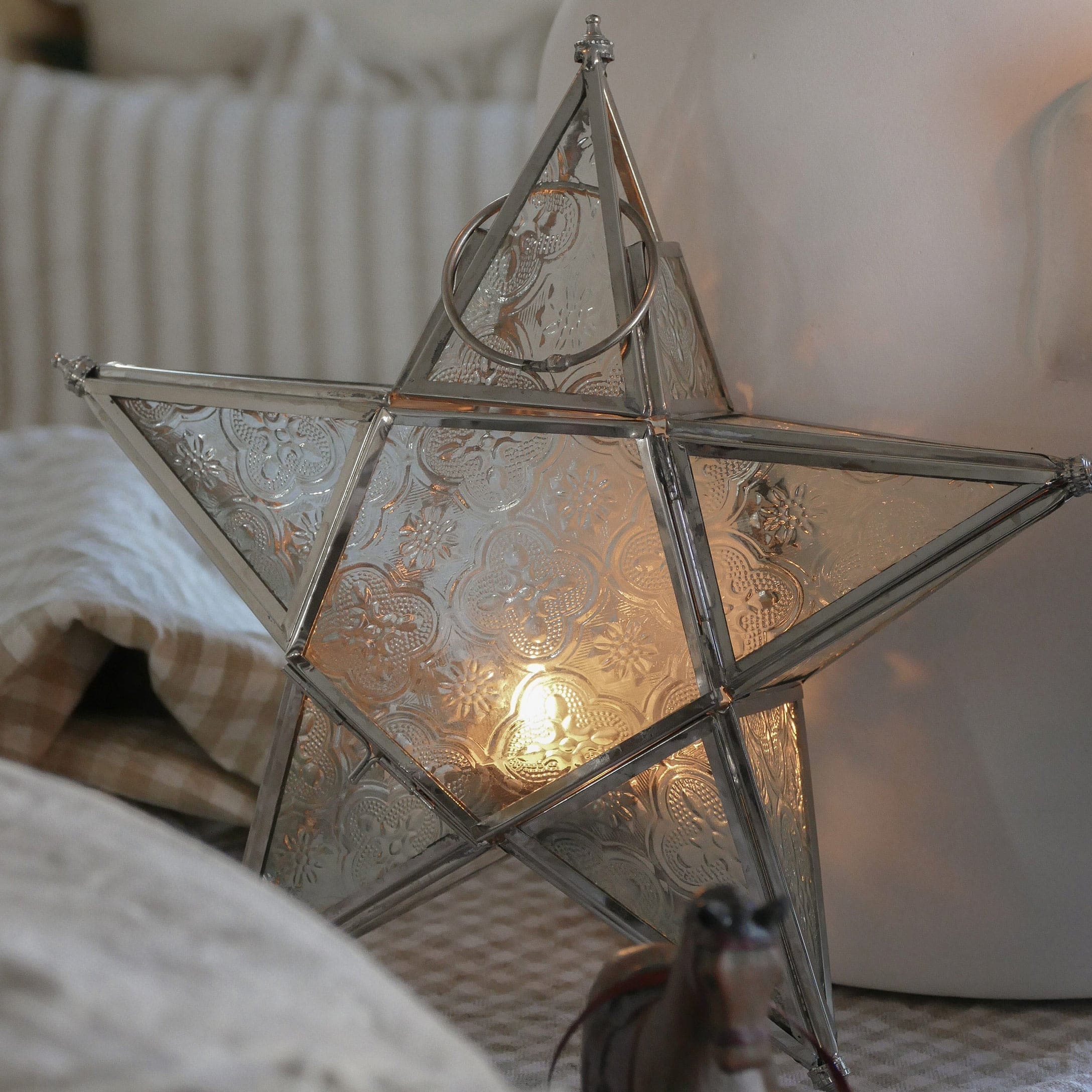 Metalen stervormige lantaarn met decoratief patroon en warm licht, feestelijke woondecoratie