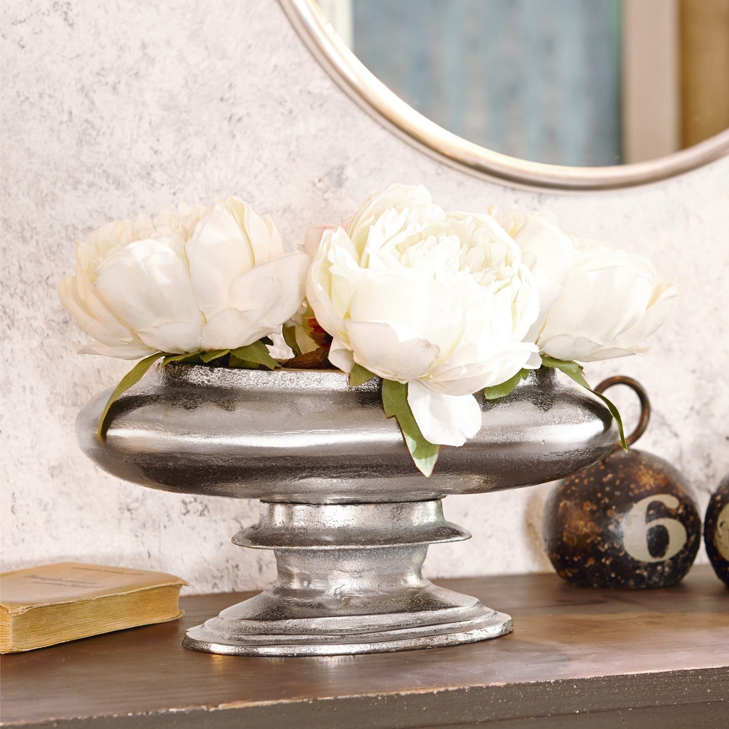 Decoratieve zilverkleurige metalen schaal met witte bloemen op houten tafel, vintage stijl