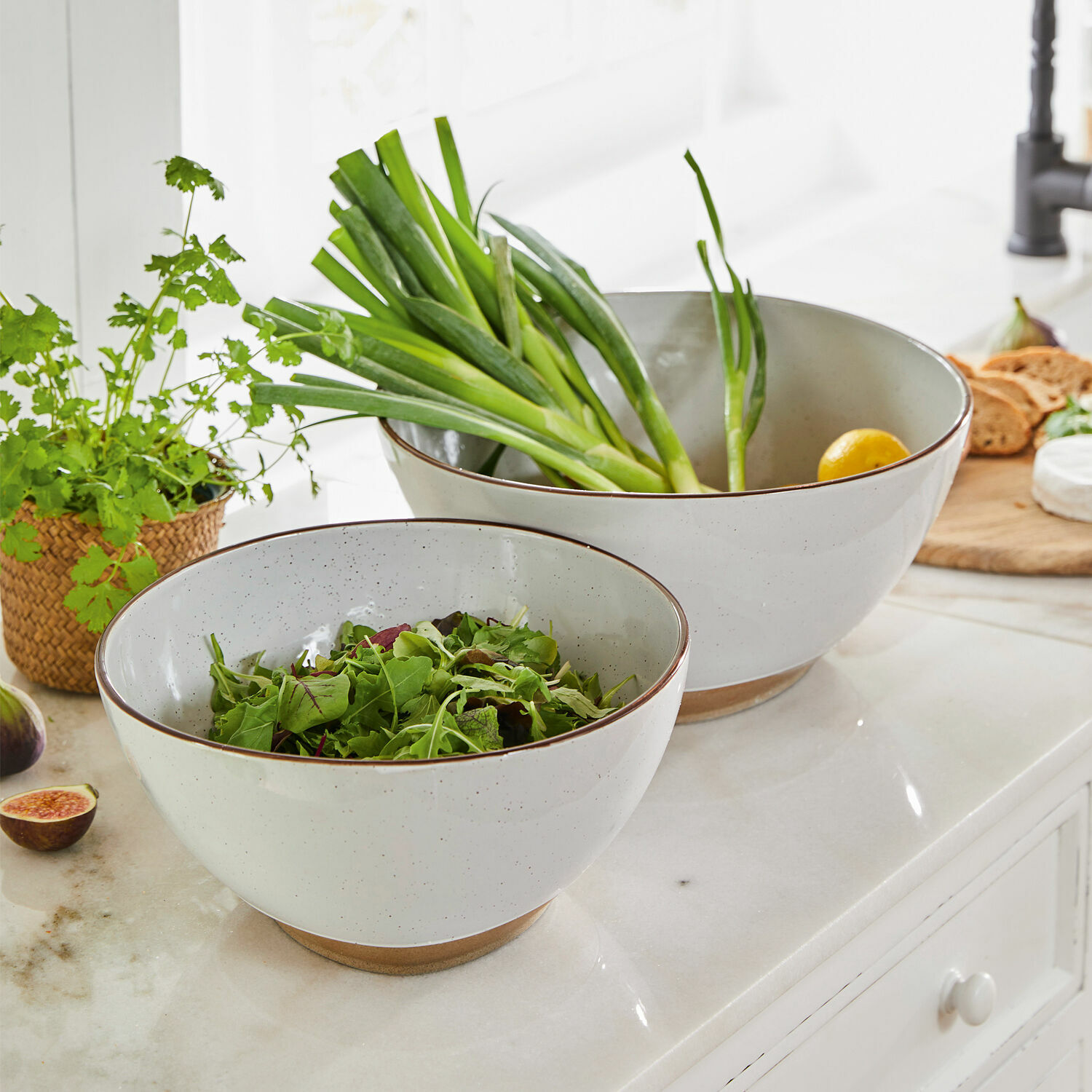 Set van twee witte keramische kommen met bruine bodem, perfect voor salades en verse groenten