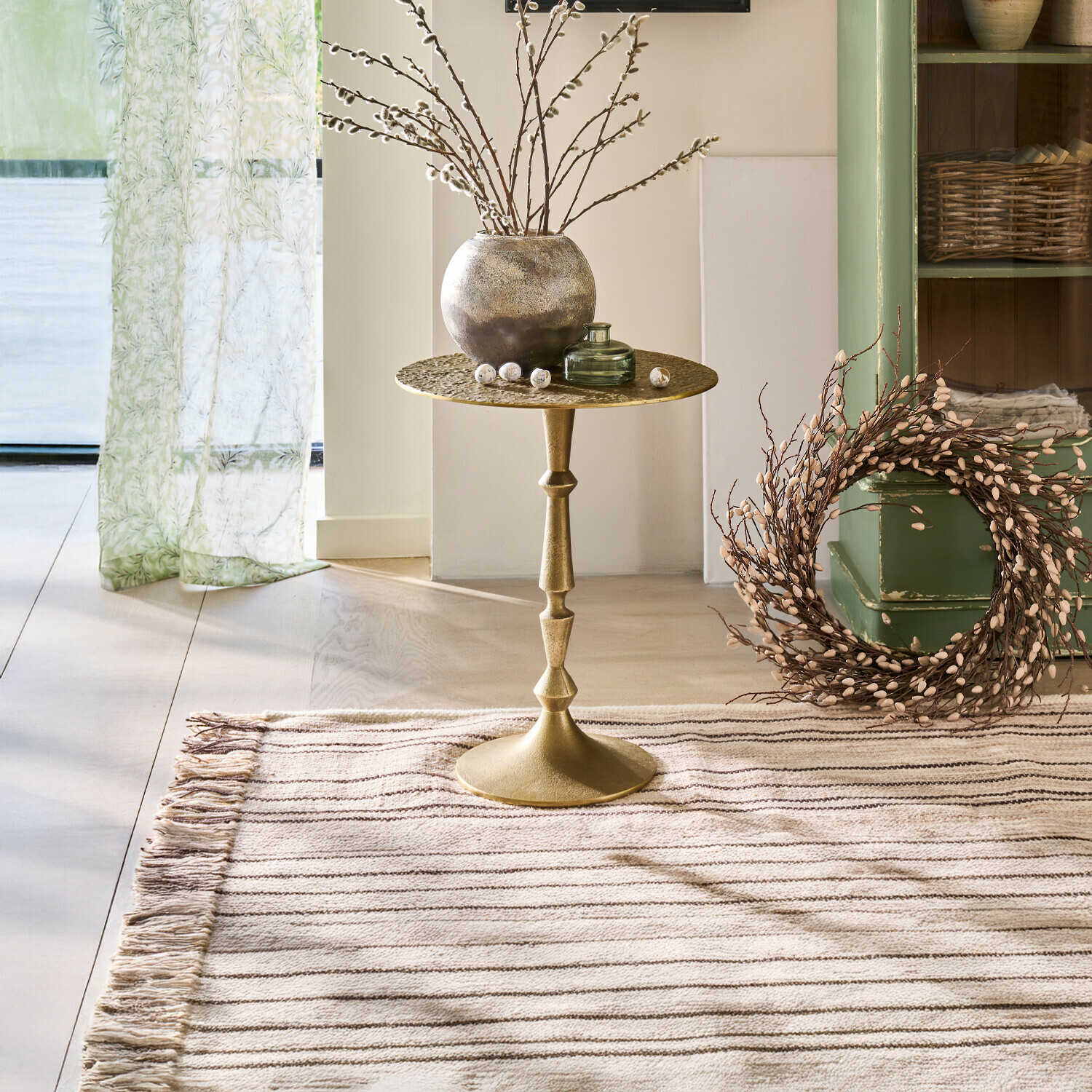 Bijzettafel Boissiére Gouden metalen bijzettafel met decoratieve vaas en takken in lichte, gezellige kamer met vloerkleed