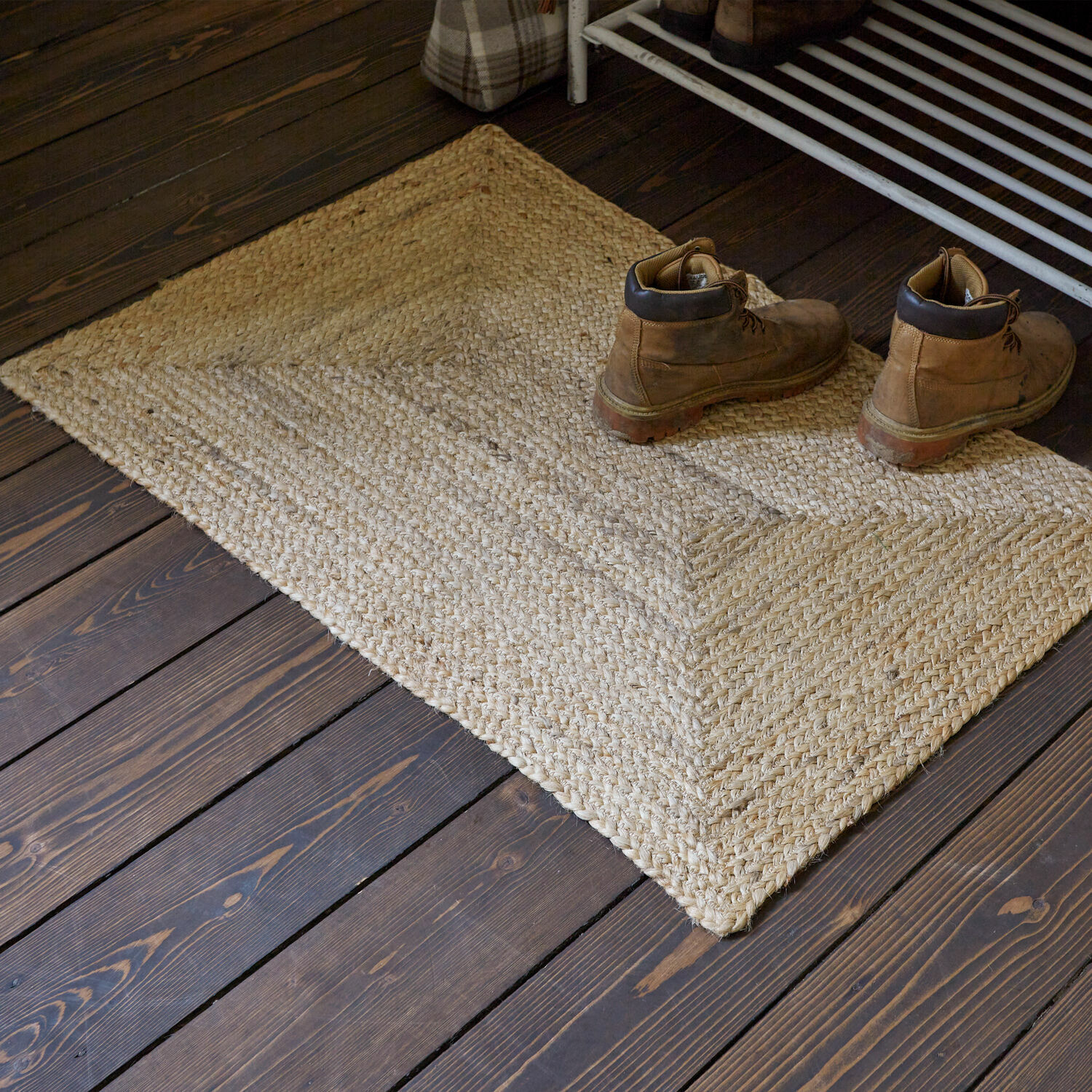 Loper Révalaine Beige jute vloerkleed op donkere houten vloer met paar bruine leren schoenen