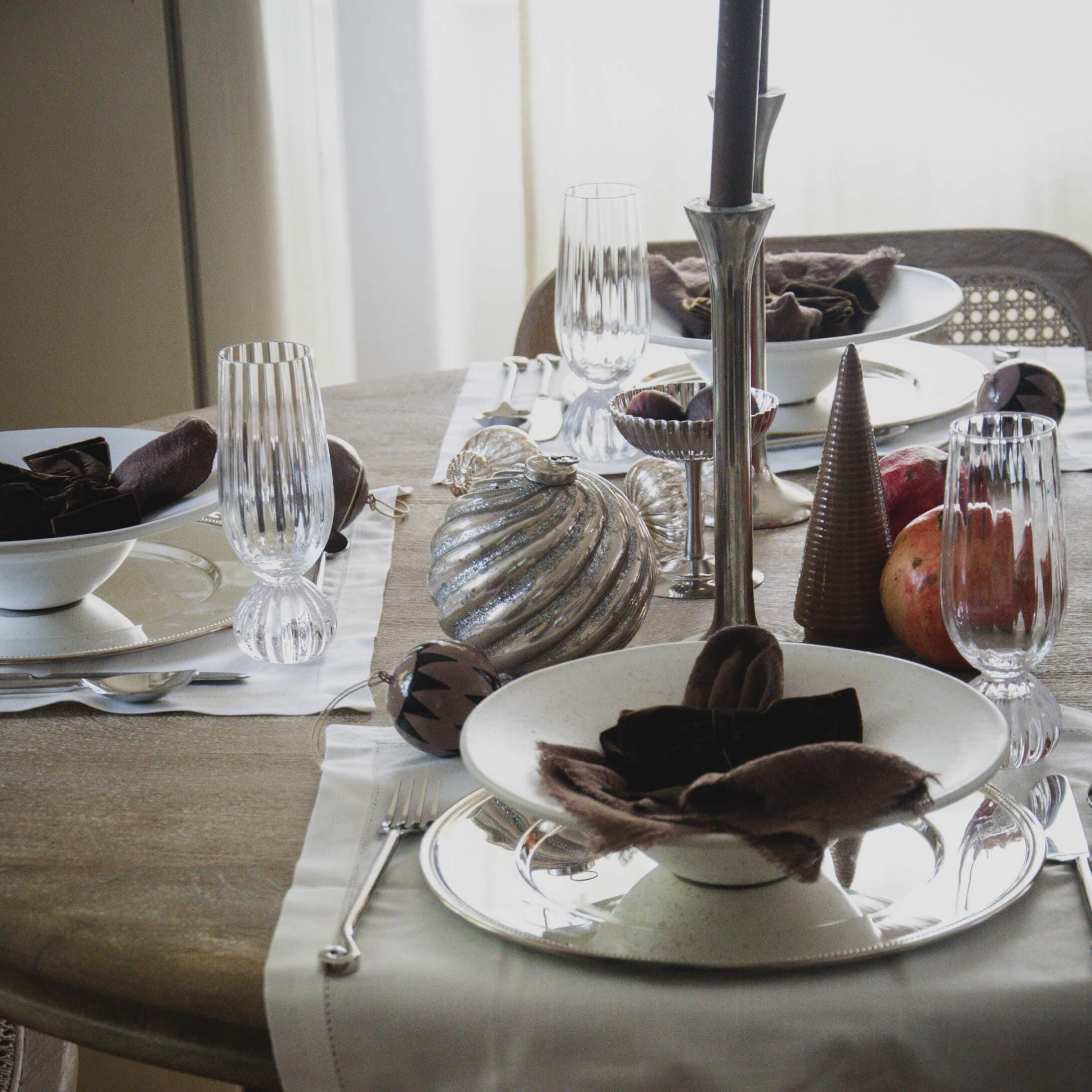 Stijlvol gedekte tafel met wit keramiek, glazen en natuurlijke decoraties voor een feestelijke maaltijd