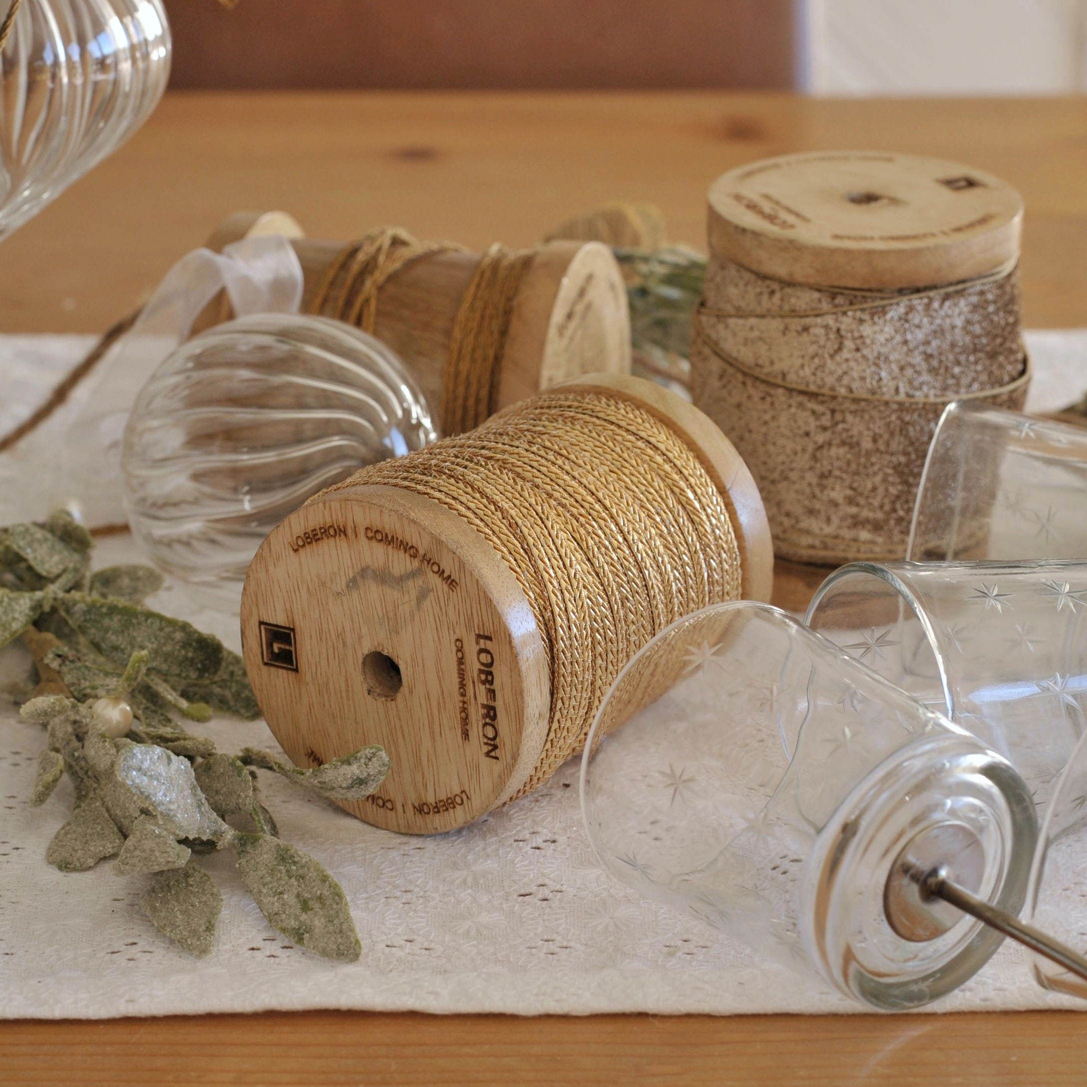 Houten spoelen met natuurlijke touw en glazen theelichthouders voor feestelijke tafeldecoratie