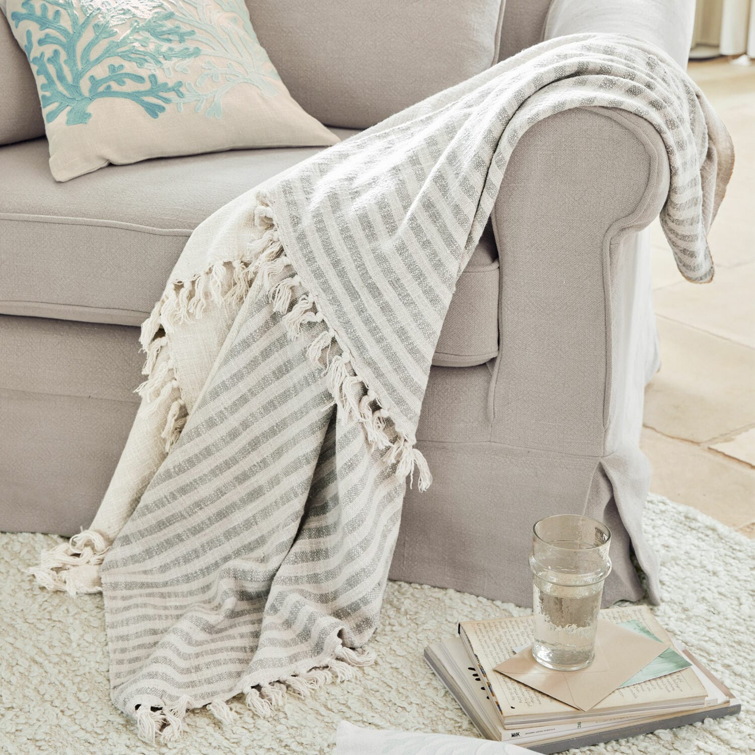 Plaid Marpent Beige gestreept deken met franjes op lichtgrijze bank, gezellige woonaccessoire