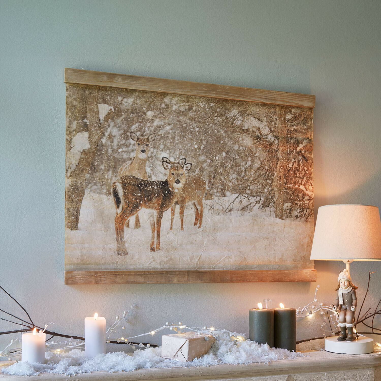 Wandafbeelding Trenaya Canvas schilderij met herten in besneeuwd bos, winterse decoratie met lamp en brandende kaarsen