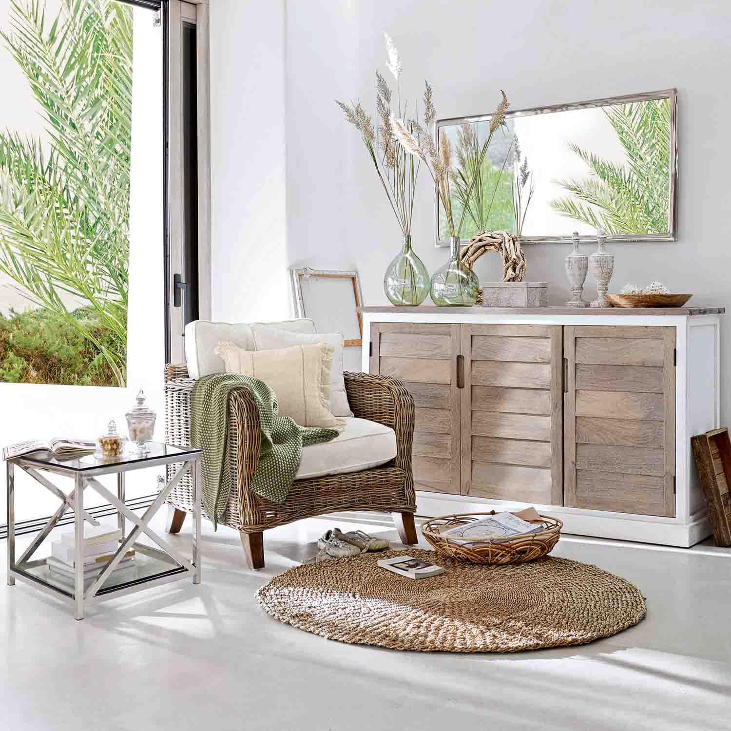 Lichte woonkamer met rotan fauteuil, lichte houten dressoir en ronde natuurlijke vloerkleed voor een gezellige sfeer