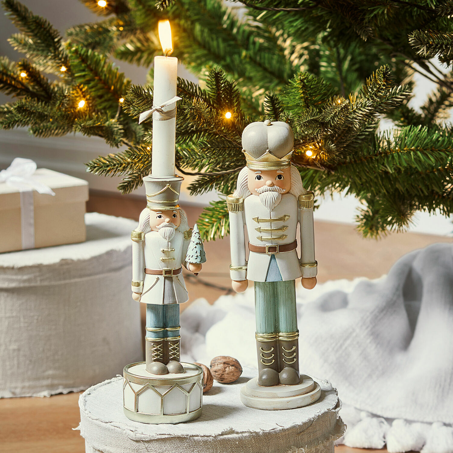 Houten notenkrakerfiguren in wit en groen voor een kerstachtergrond met verlichte dennentakken