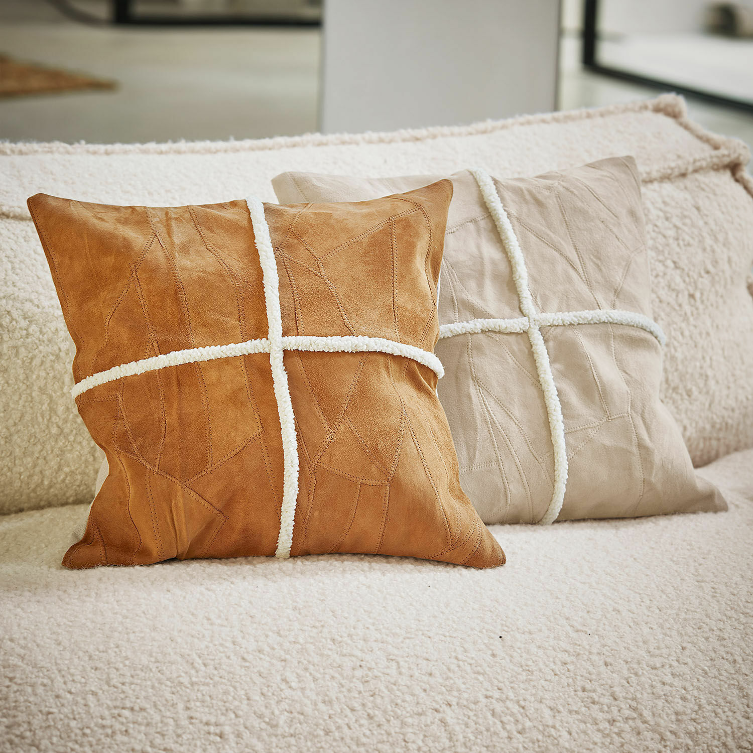Kussenhoes set van 2 Raminya Twee decoratieve suède kussens in bruin en beige met witte sierstrepen op een bank