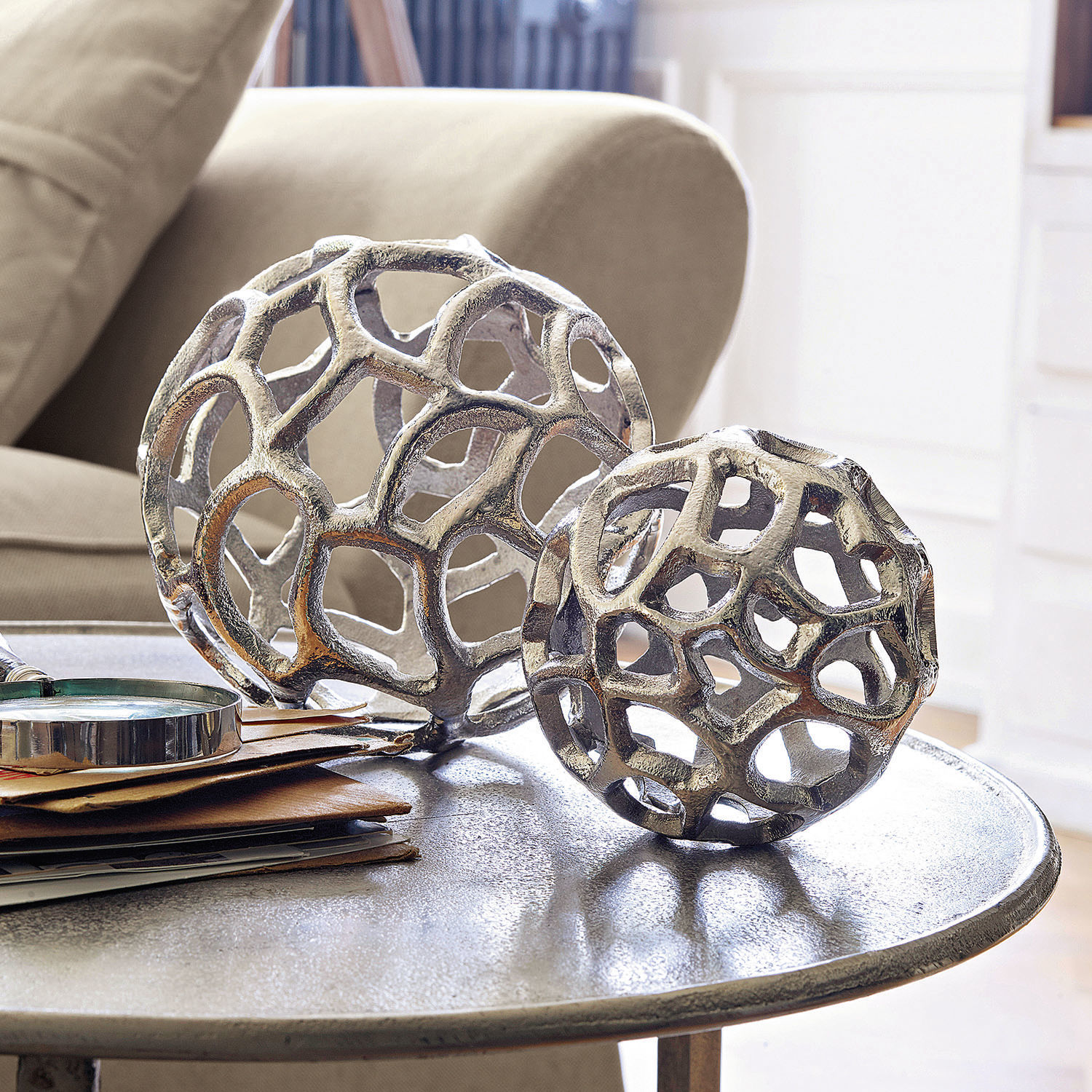 Decoratieve bal, set van 2 Venay Decoratieve zilverkleurige metalen opengewerkte bollen op een salontafel