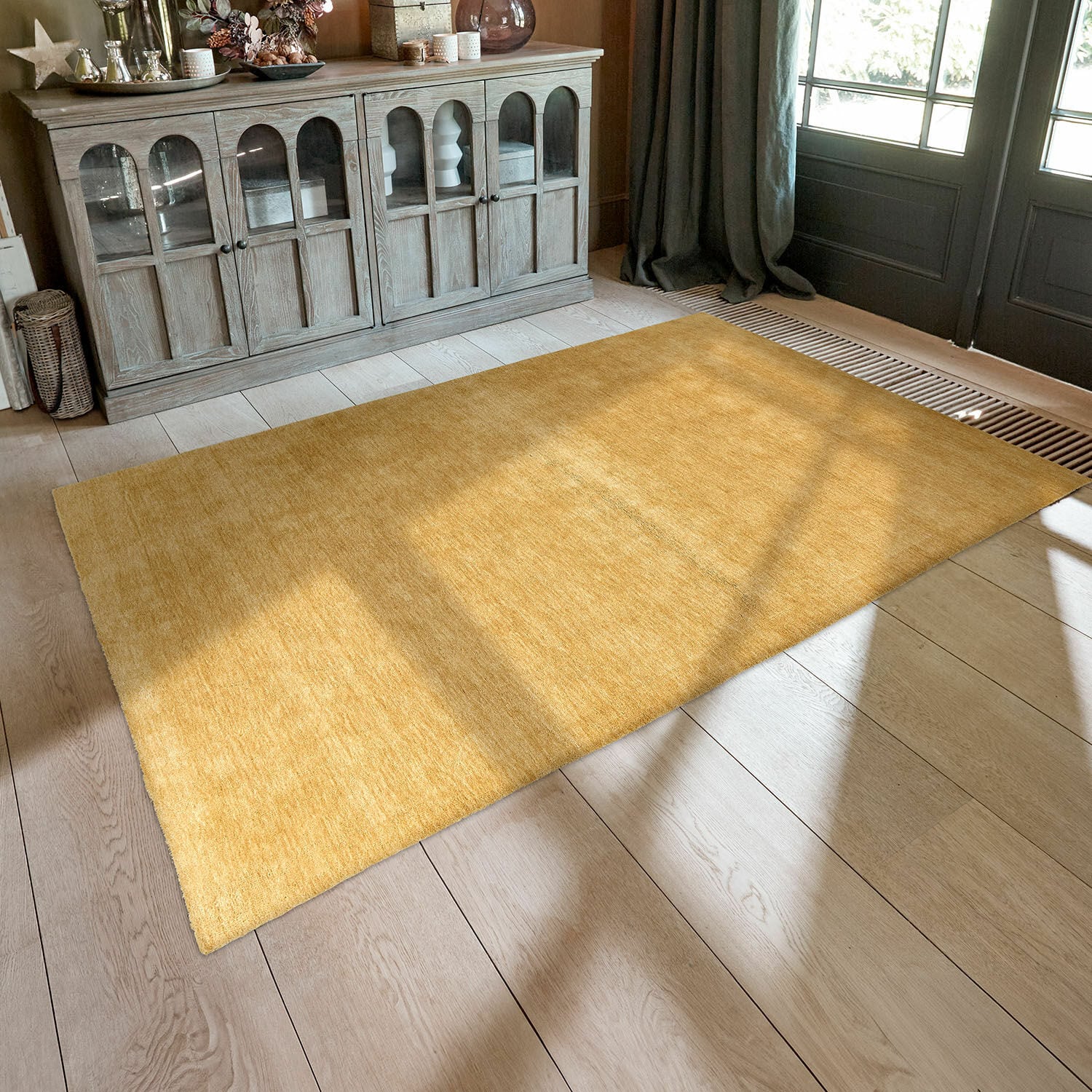 Vloerkleed Cresil Gele vloerkleed van zacht materiaal op lichte houten vloer in gezellige woonkamer met kast
