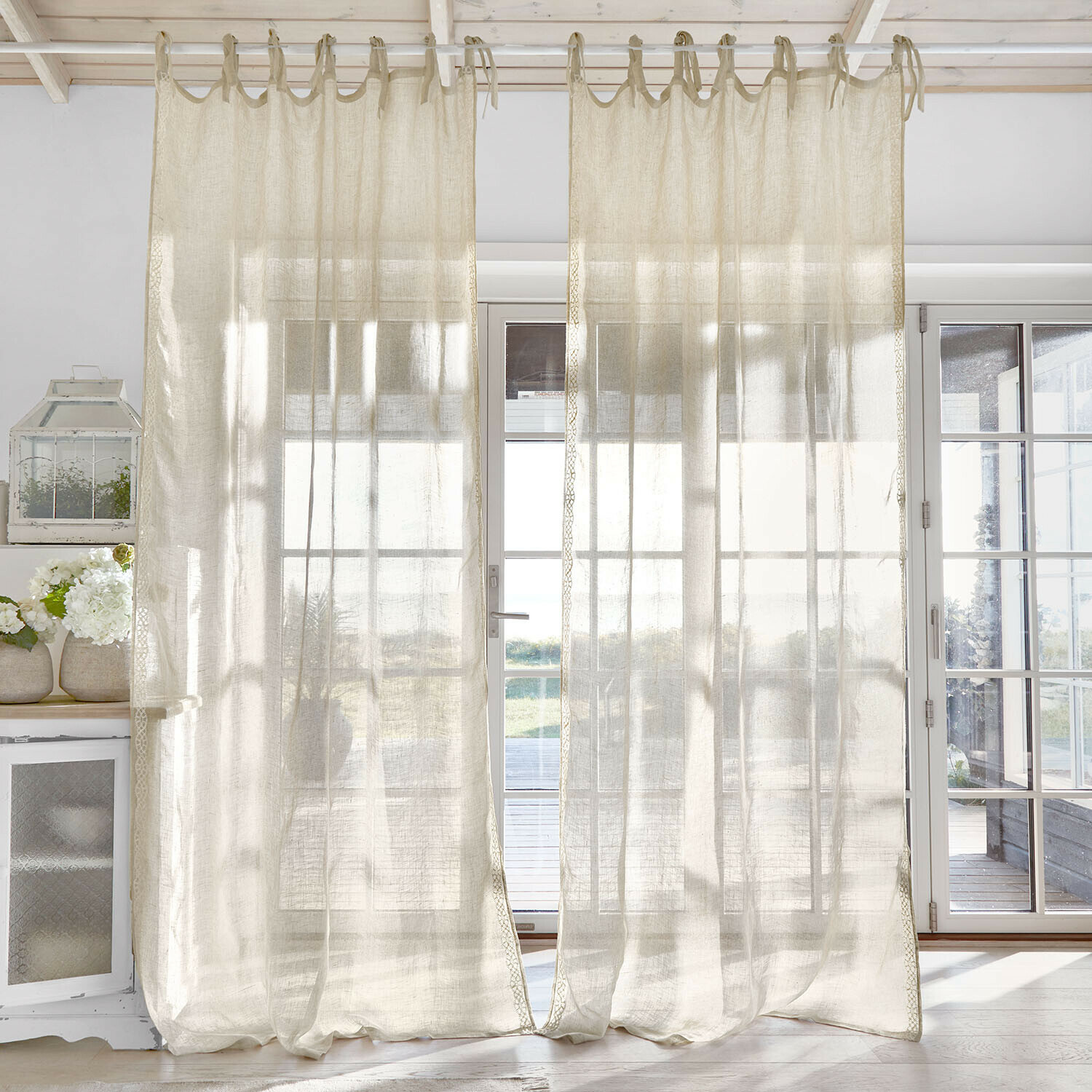 Transparante gordijnen van natuurlijk linnen die zacht licht verspreiden in een lichte kamer