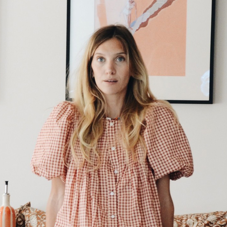 Vrouw in losse blouse met rood-wit geruit patroon, moderne casual stijl