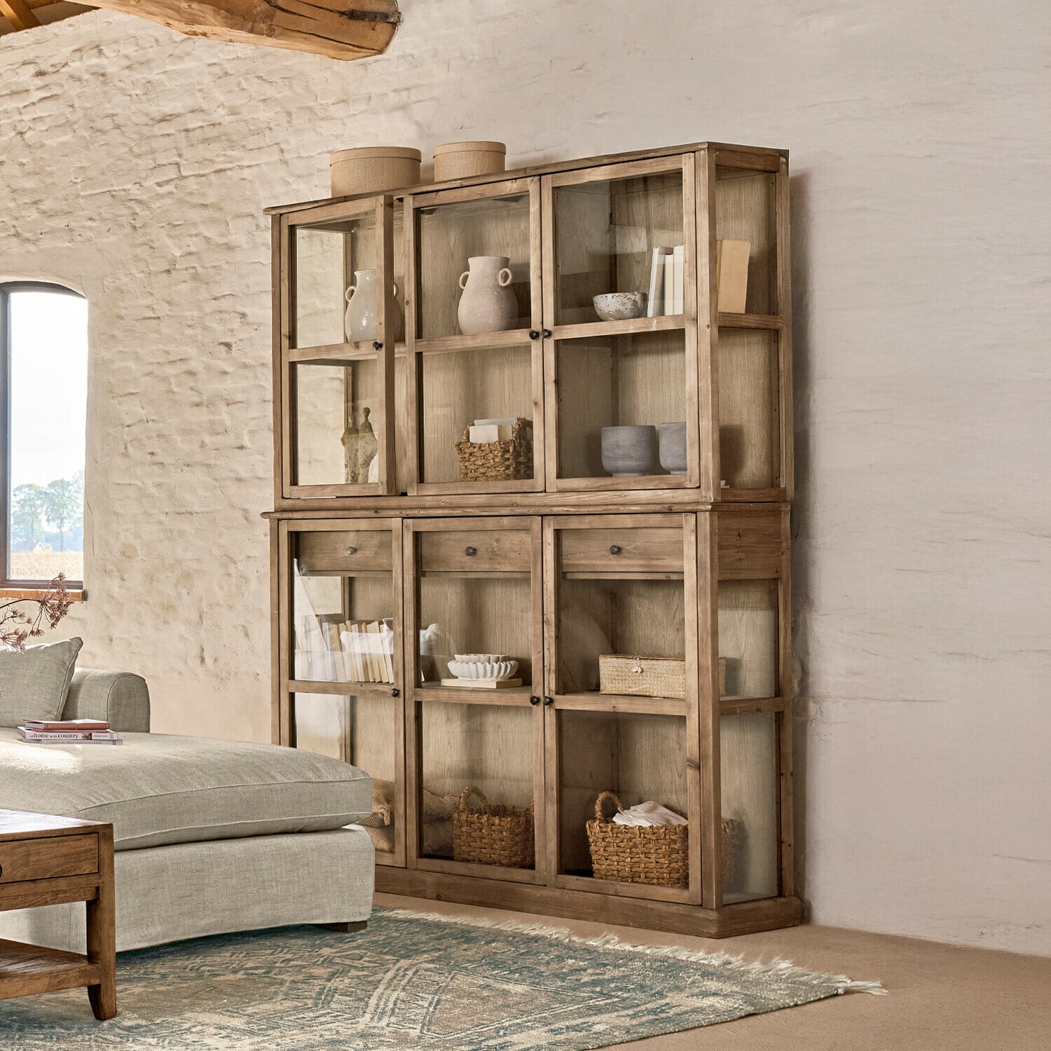 Grote houten vitrinekast met glazen deuren en planken, natuurlijke houtkleur, woonkamermeubel