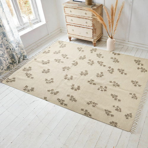 Beige vloerkleed met bloemmotief en franjes, zacht materiaal, vloerdecoratie in lichte kamer