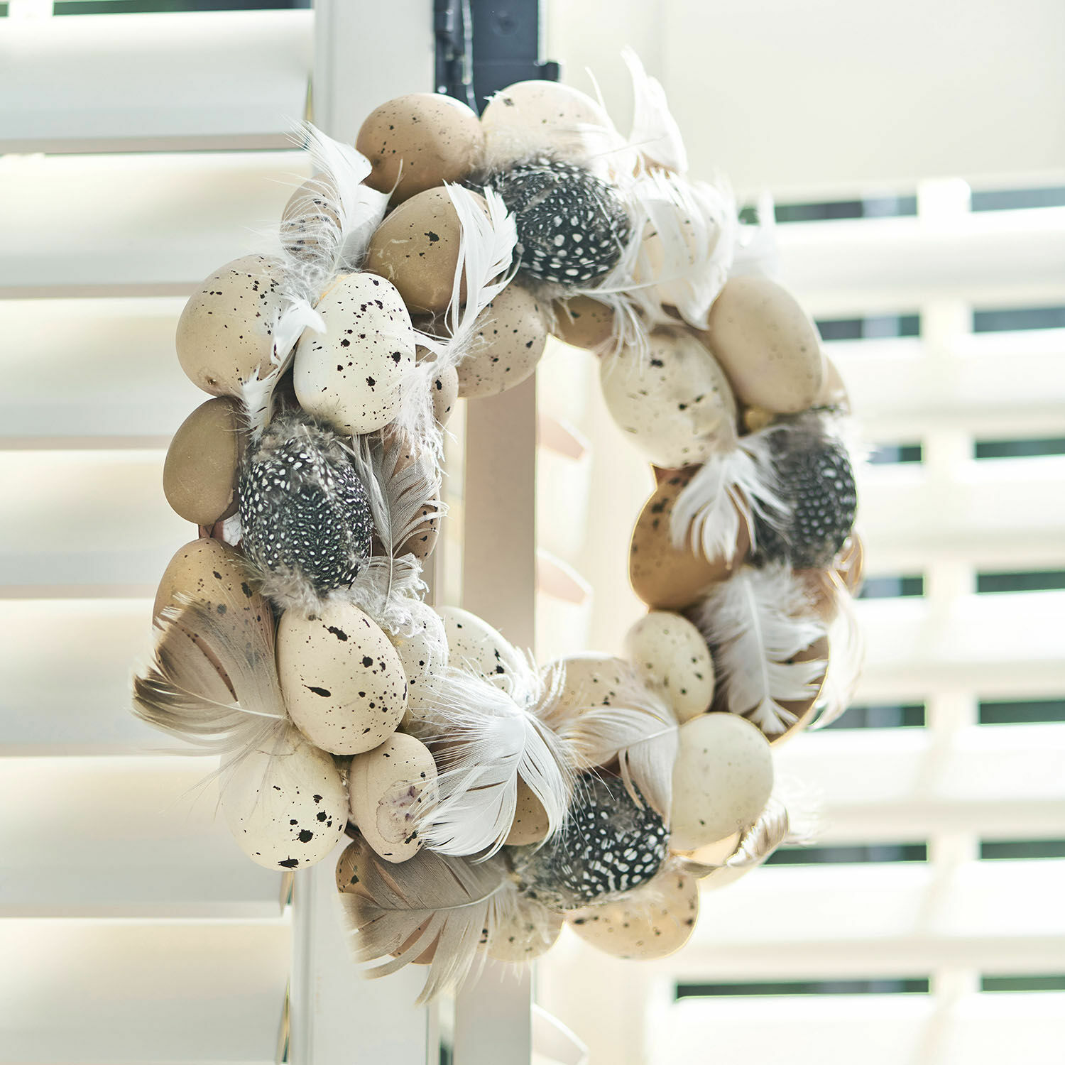 Eierkrans Harera Decoratieve krans met beige en zwarte veren en nep-eieren voor lentebehang