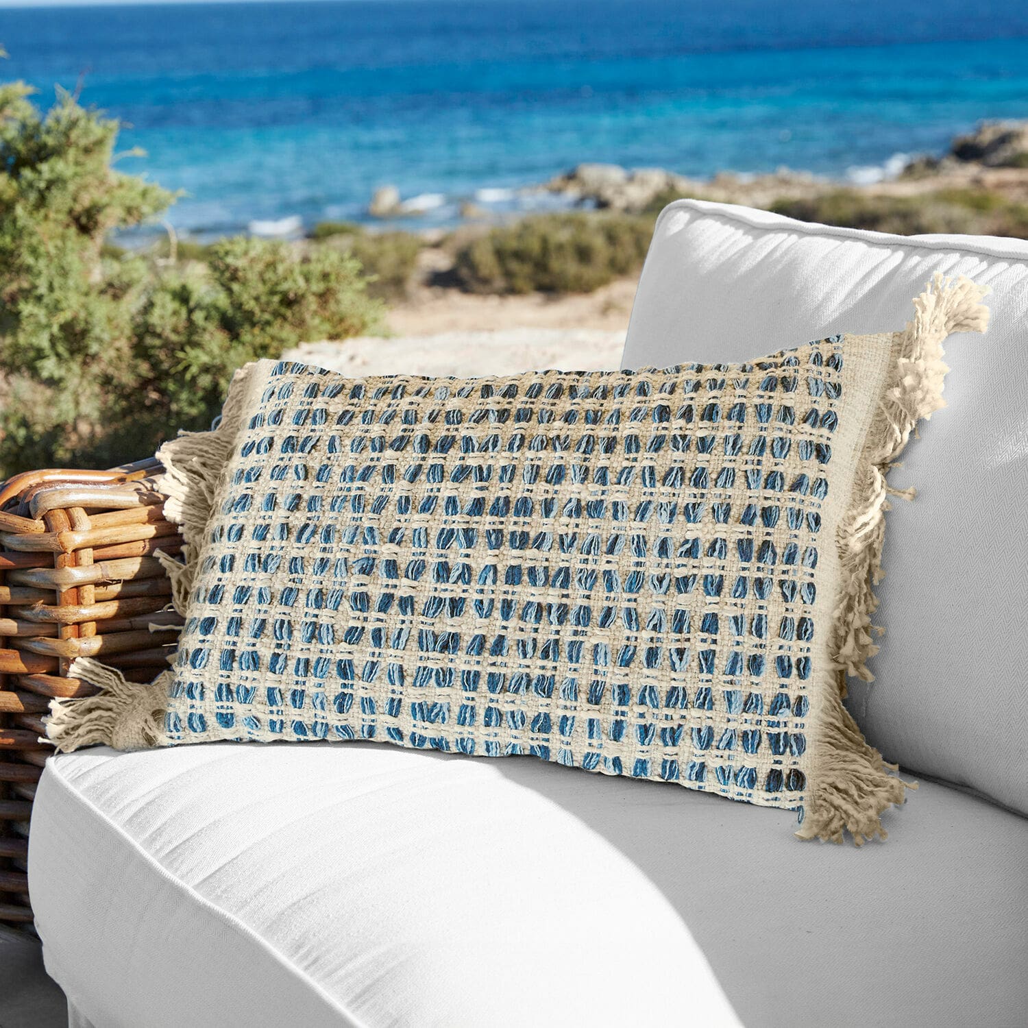 Kussenhoes Monrovie Decoratief katoenen kussen in crème-blauwe ruit met franjes op witte buitenbank