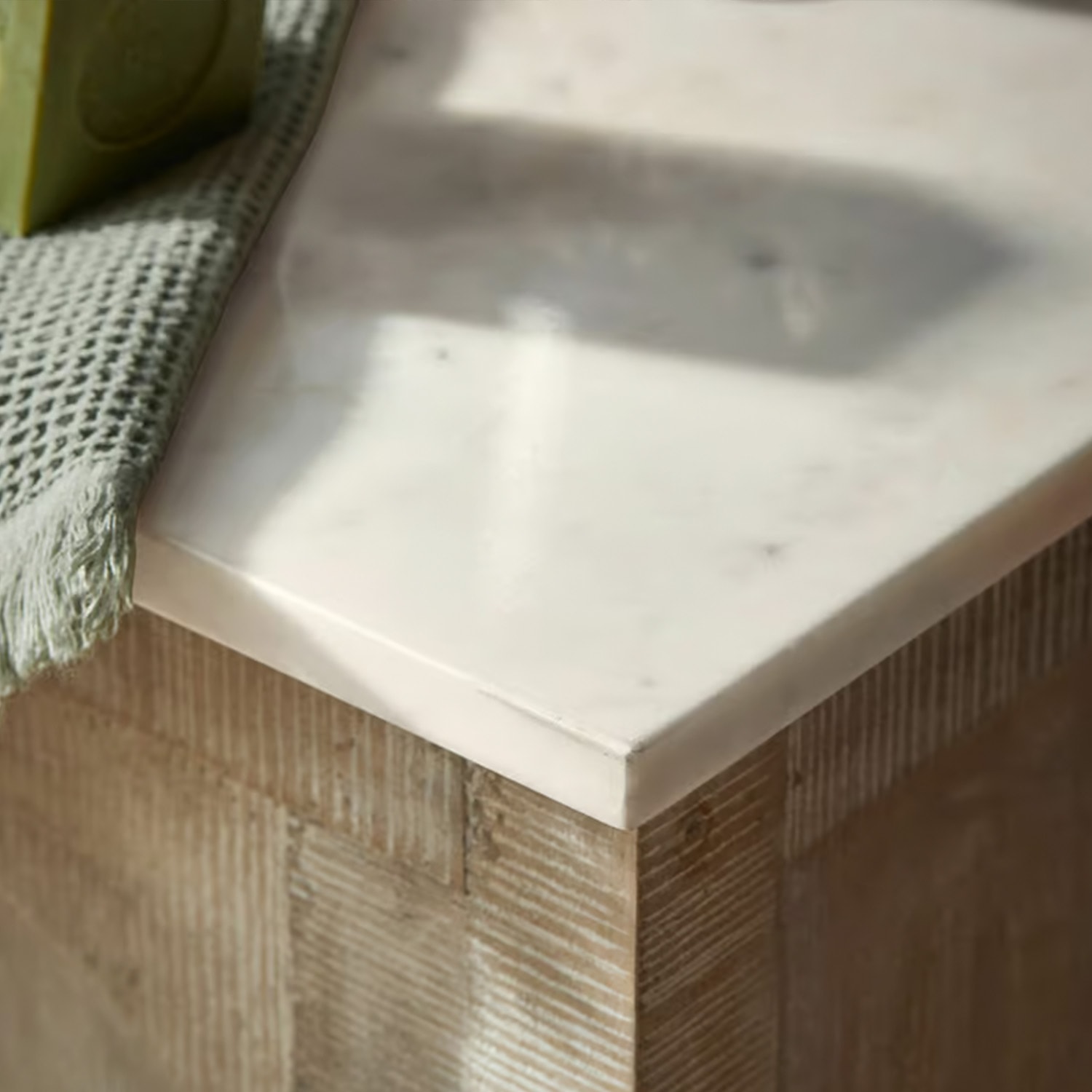 Witte marmeren blad op houten onderstel met groene stoffen handdoek, modern meubel