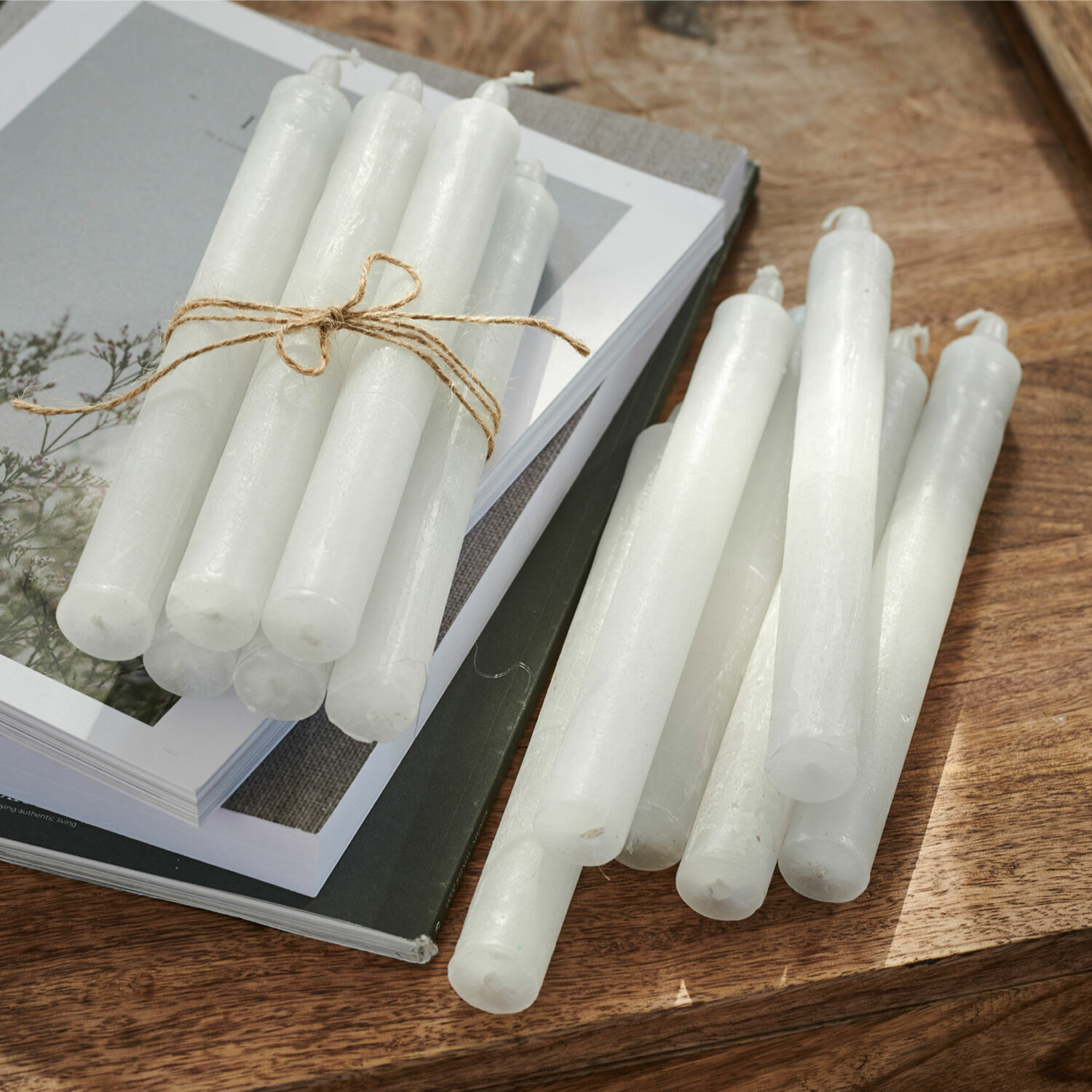 Kaars set van 12 Bauceau Set witte kaarsen van was op houten tafel met boeken, interieurdecoratie