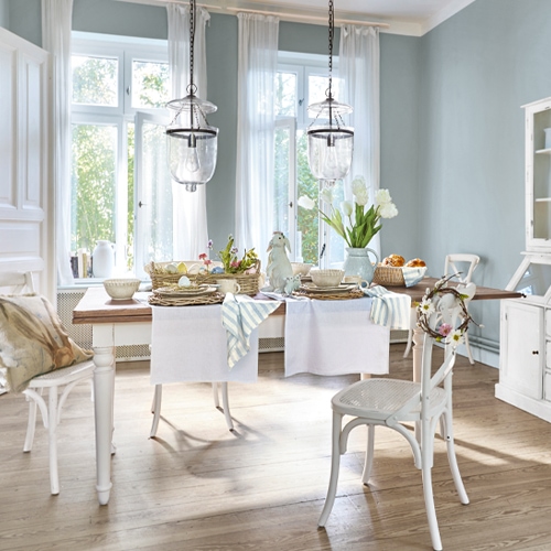 Rustieke eetkamer met witte houten tafel en stoelen, lichte pastelkleuren decoraties