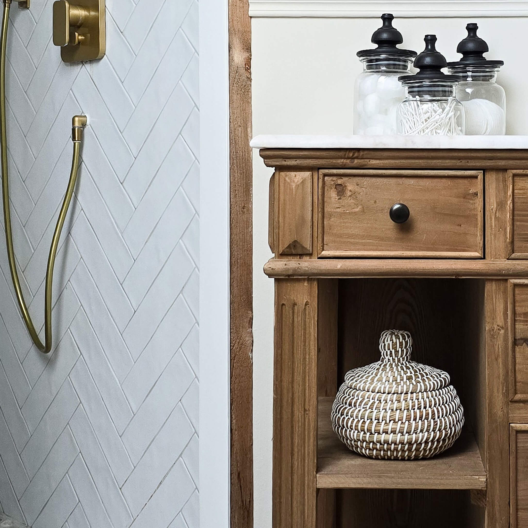 Rustieke houten badkamerkast met wit blad en glazen potten voor accessoires