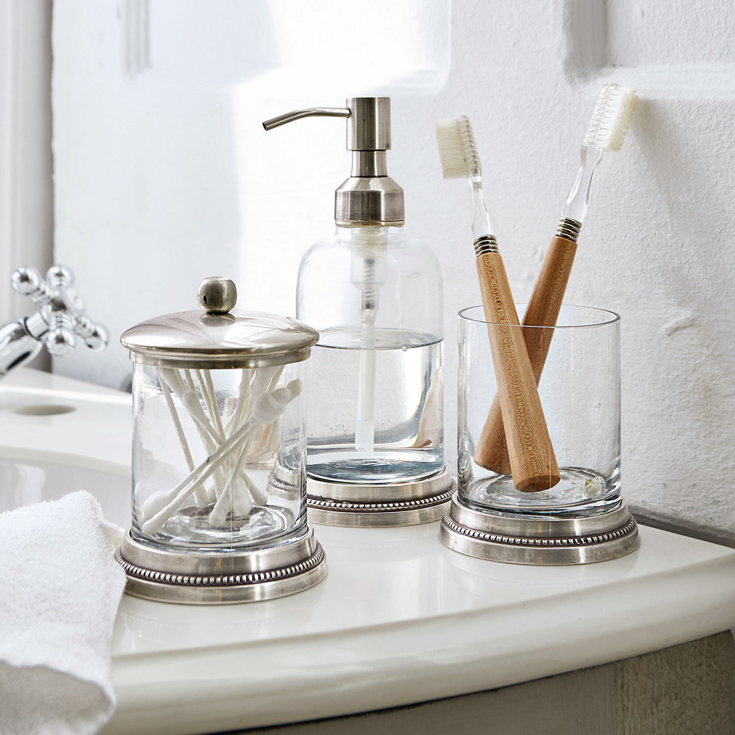 Badset Drinapoly Glazen badkameraccessoires met metalen accenten op witte wastafel met bamboe tandenborstels