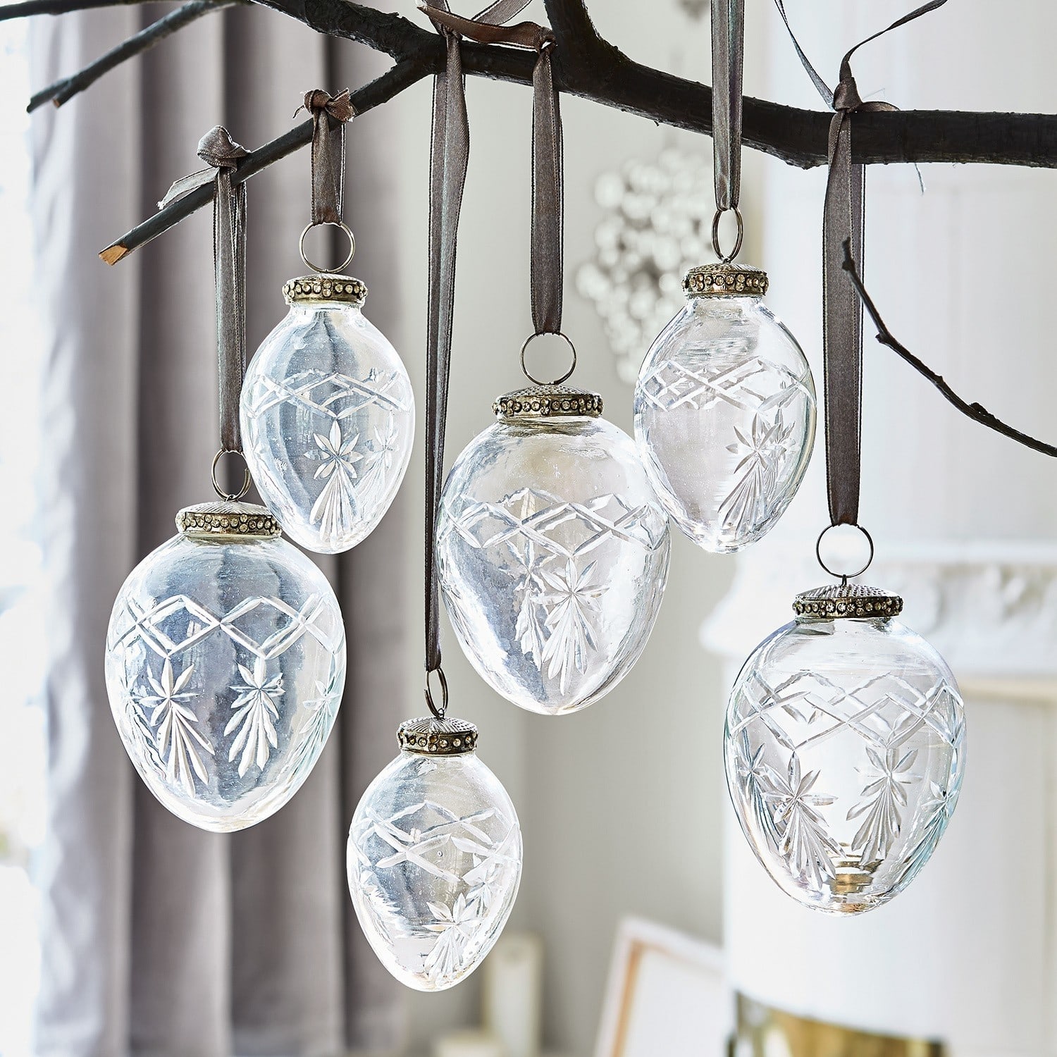 Transparante glazen hangers met gegraveerd patroon aan bruine linten voor kerstdecoratie