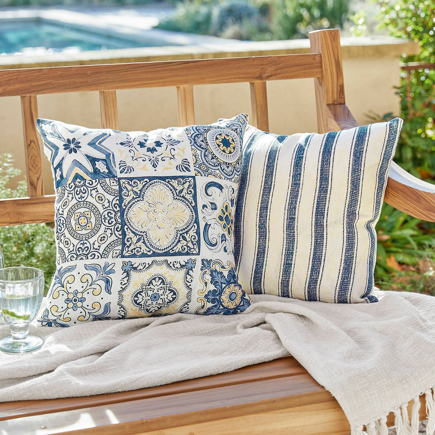 Kussenhoes set van 2 Bourrignon Twee decoratieve katoenen kussens met blauw-witte patronen op een houten bank in de tuin