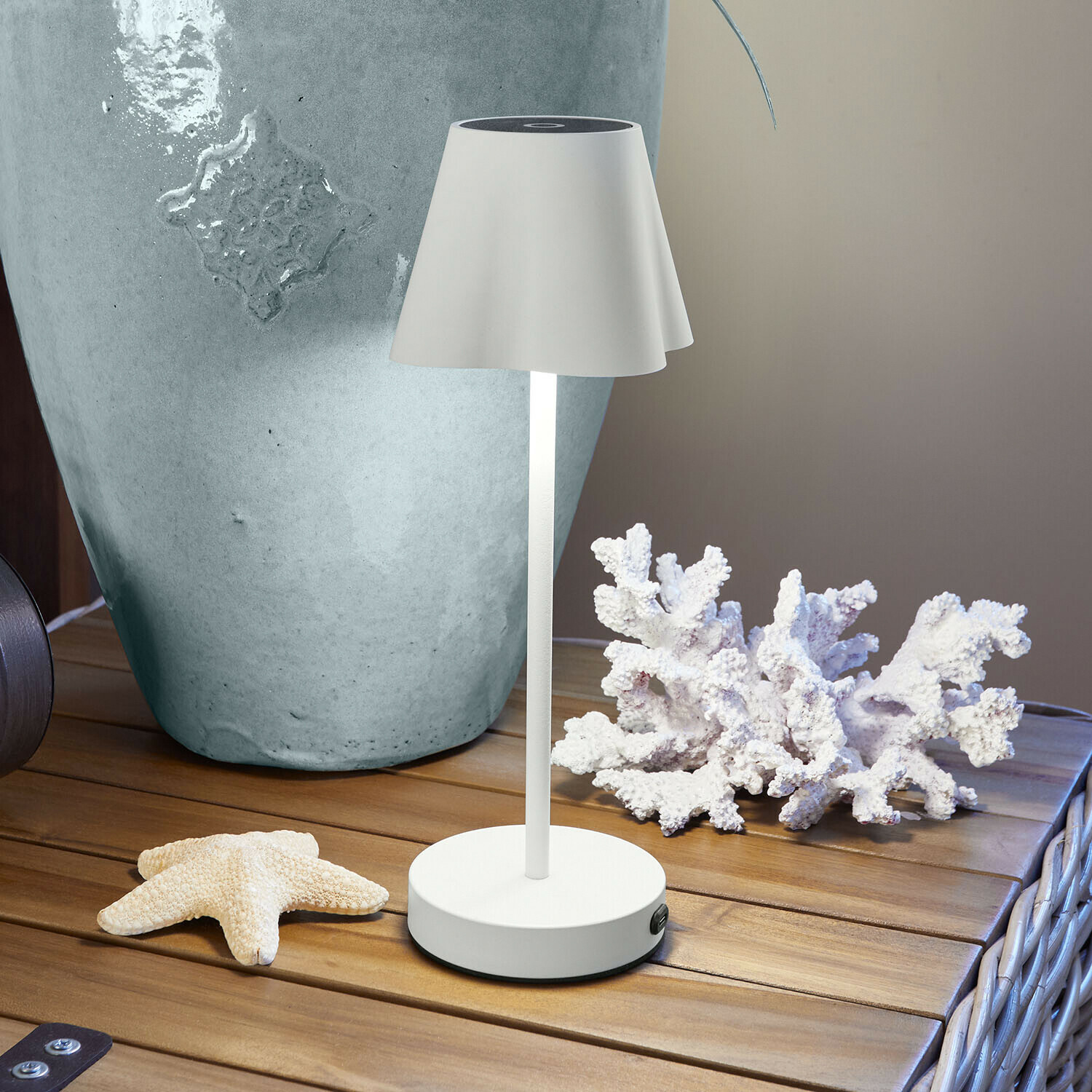 Oplaadbare tafellamp Tenari Beige metalen tafellamp op houten tafel met maritieme decoratie en grote vaas