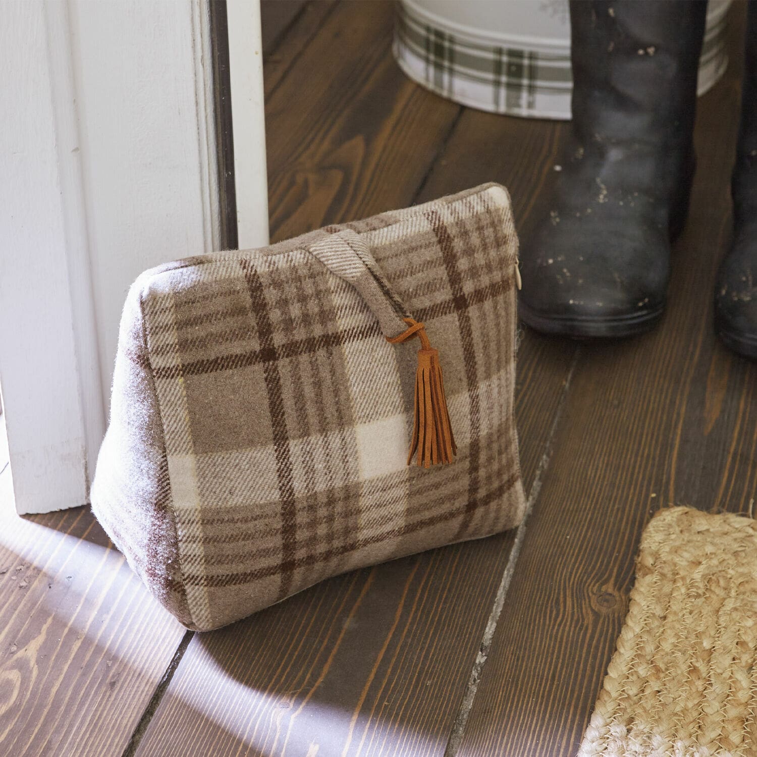 Deurstopper Ersac Beige geruite tas van zachte stof met bruine kwast op houten vloer