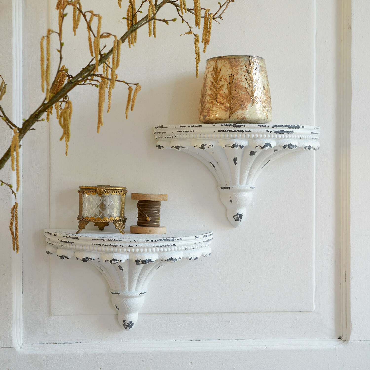 Wandconsole set van 2 Liara Twee witte wandplanken van verouderd metaal met decoratieve vintage voorwerpen aan de muur