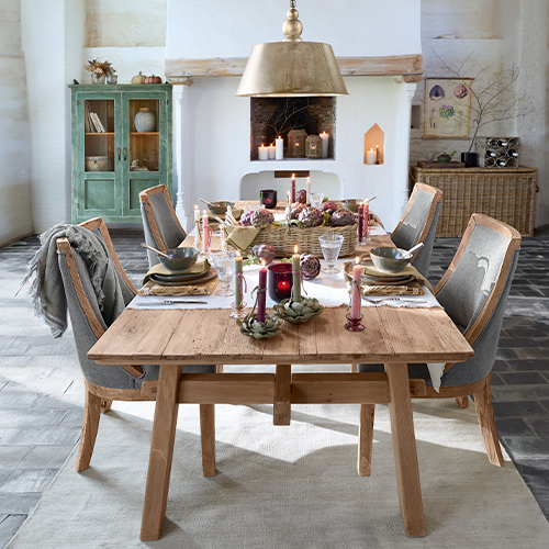 Rustieke houten eettafel met grijze gestoffeerde stoelen en feestelijke decoratie