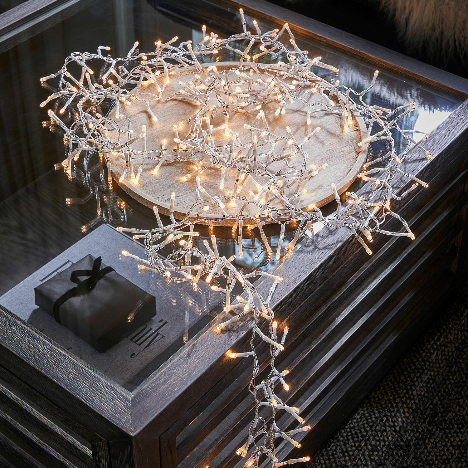 Lichtsnoer Aedara LED-lichtsnoer met warm wit licht en transparante kabel op houten dienblad op glazen tafel