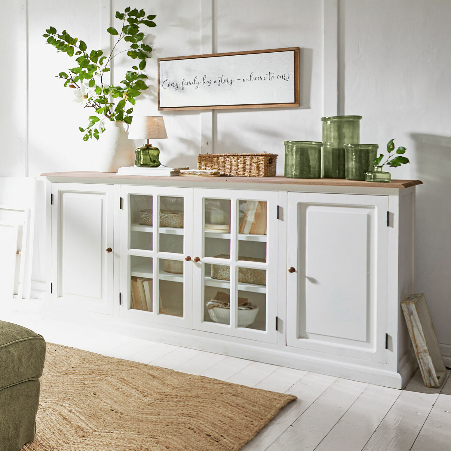 Buffetkast Kostan Witte houten dressoir met glazen deuren en licht houten blad in een lichte woonkamer