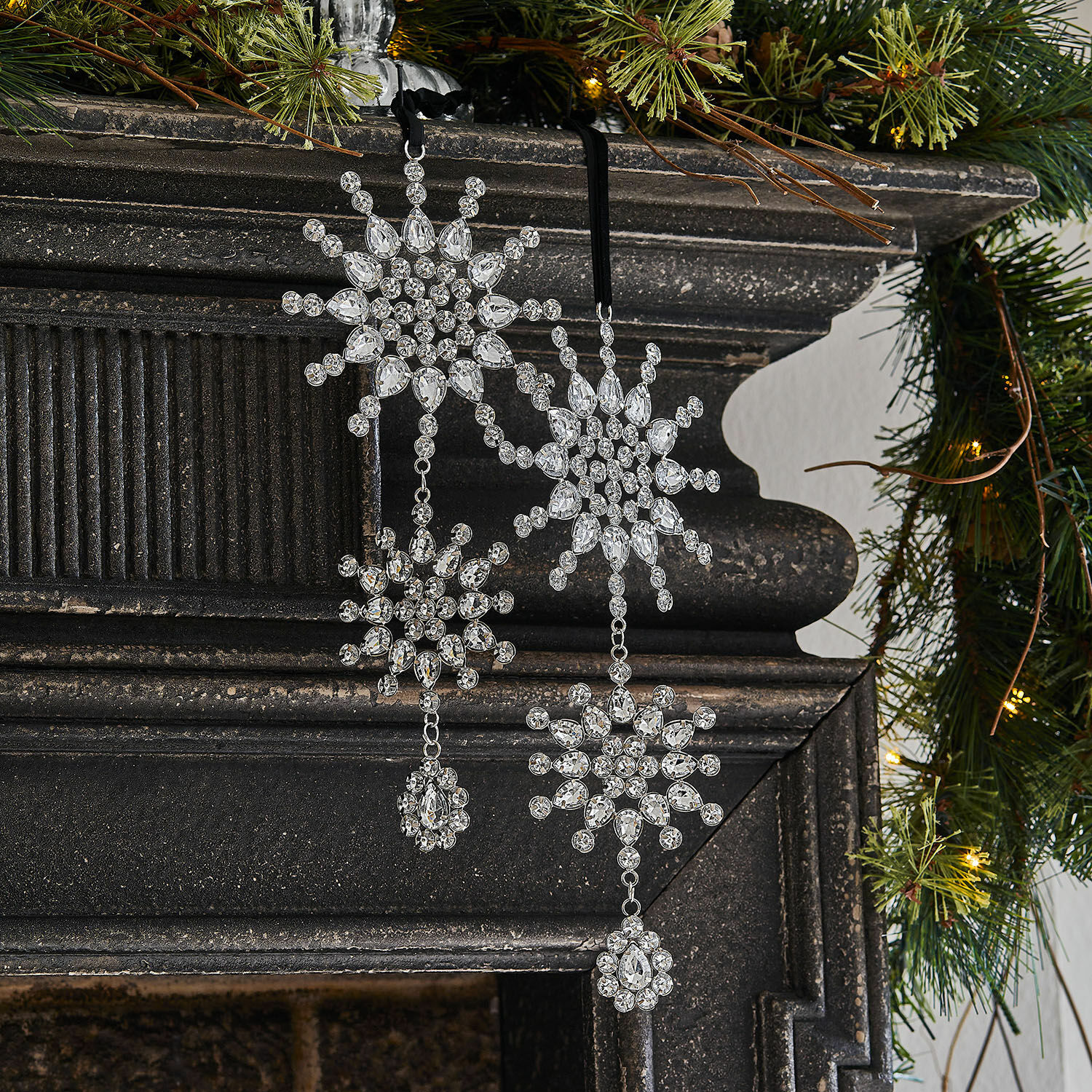 Hanger set van 2 Klerven Kerstdecoratie van transparante kristallen in sneeuwvlokvorm aan zwarte open haard met groene takken