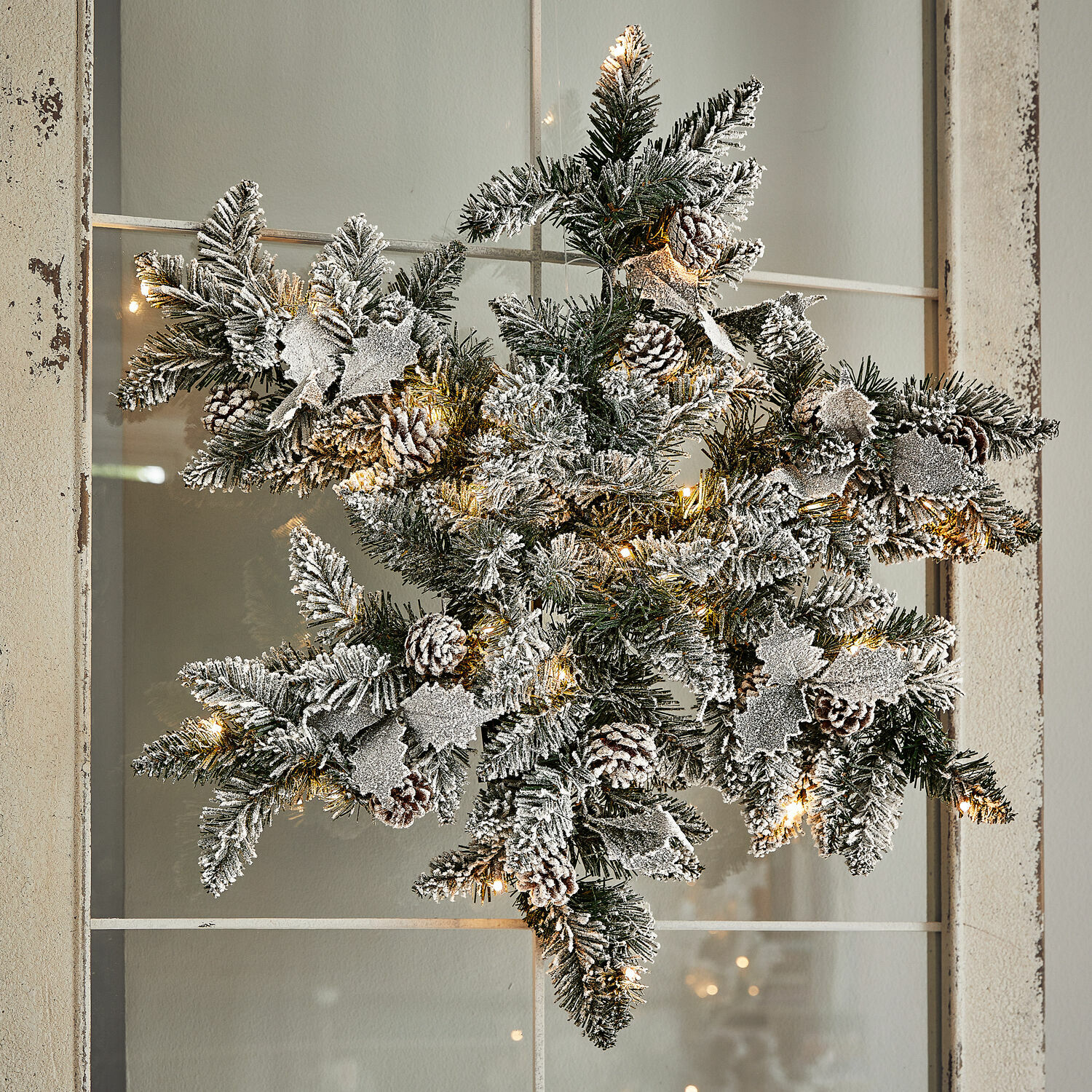 Ledkerststuk Azimara Kerstster van groene takken met dennenappels en sneeuwachtig effect, verlicht met warme LED-lampjes