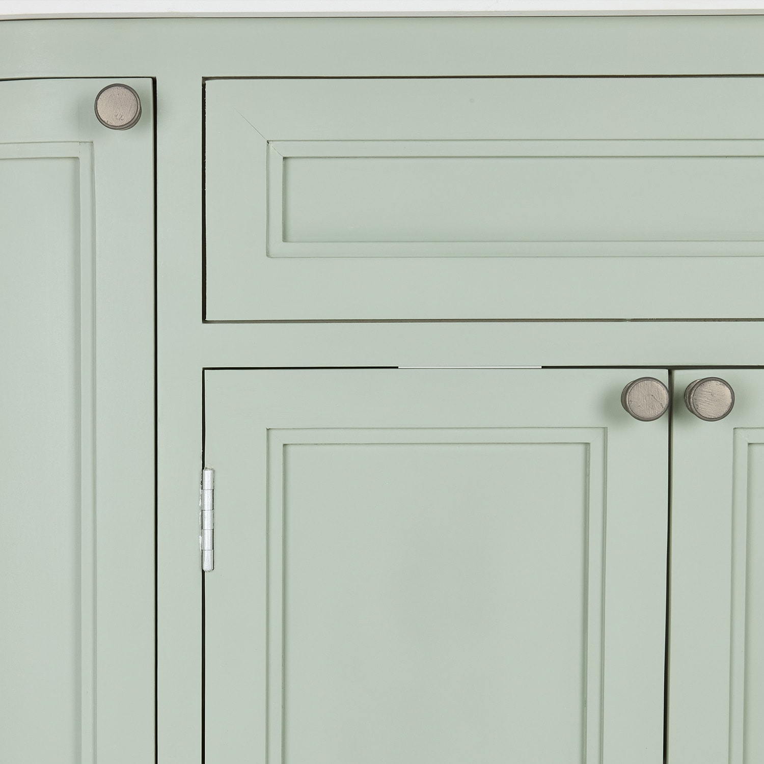 Pastelgroene kastdeur met houten knoppen en klassieke panelen voor opbergruimte