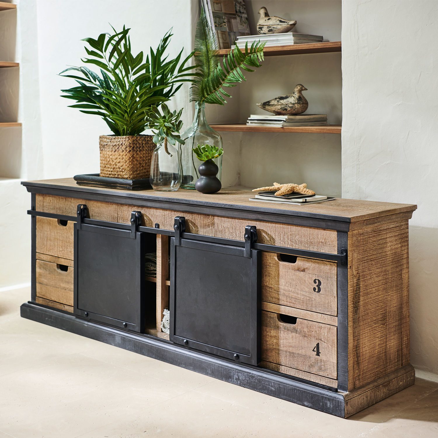 Sideboard Vulmont Dressoir van mangohout met zwarte metalen schuifdeuren en groene planten in industriële stijl