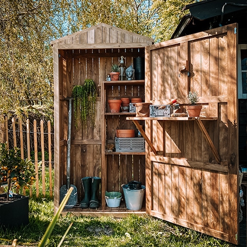 Houten tuinhuisje in natuurlijke kleur met planken en tuingereedschap, praktische opslag voor tuinbenodigdheden