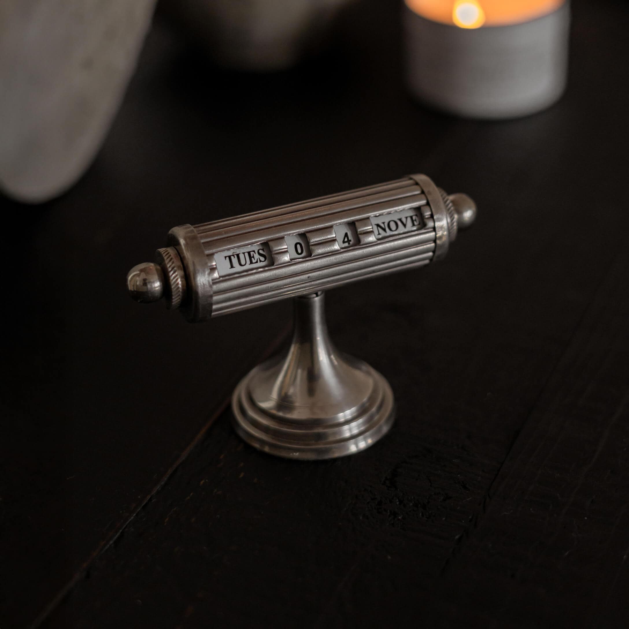 Zilverkleurige metalen bureaikalender met draaibare rollen voor datum- en daginstelling