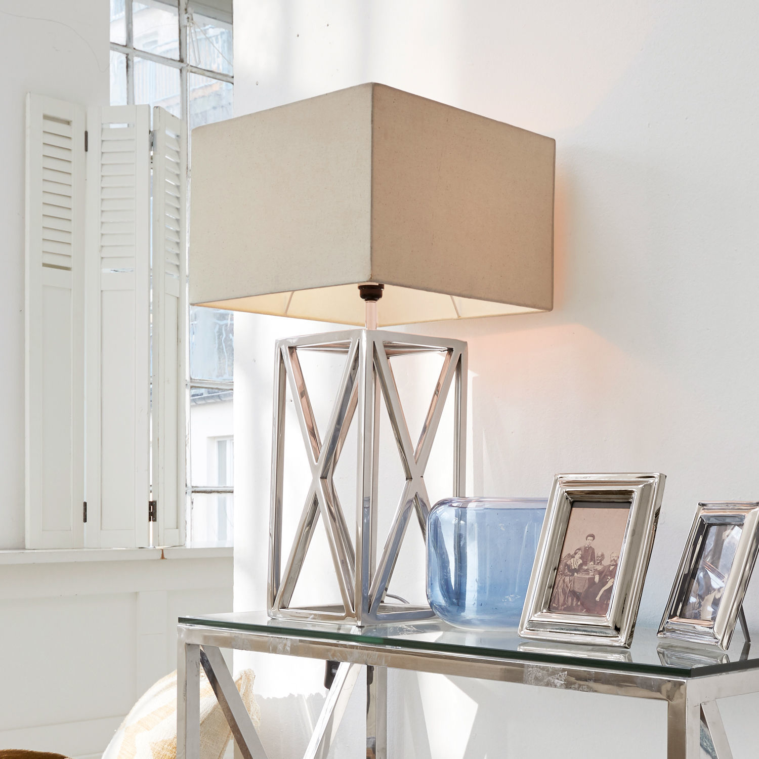Tafellamp Foix Moderne tafellamp met metalen voet en beige kap op glazen tafel in lichte kamer