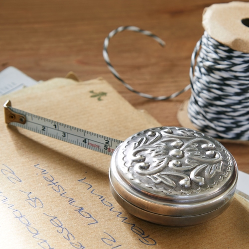 Metalen decoratieve meetlint op houten tafel met envelop en klos touw